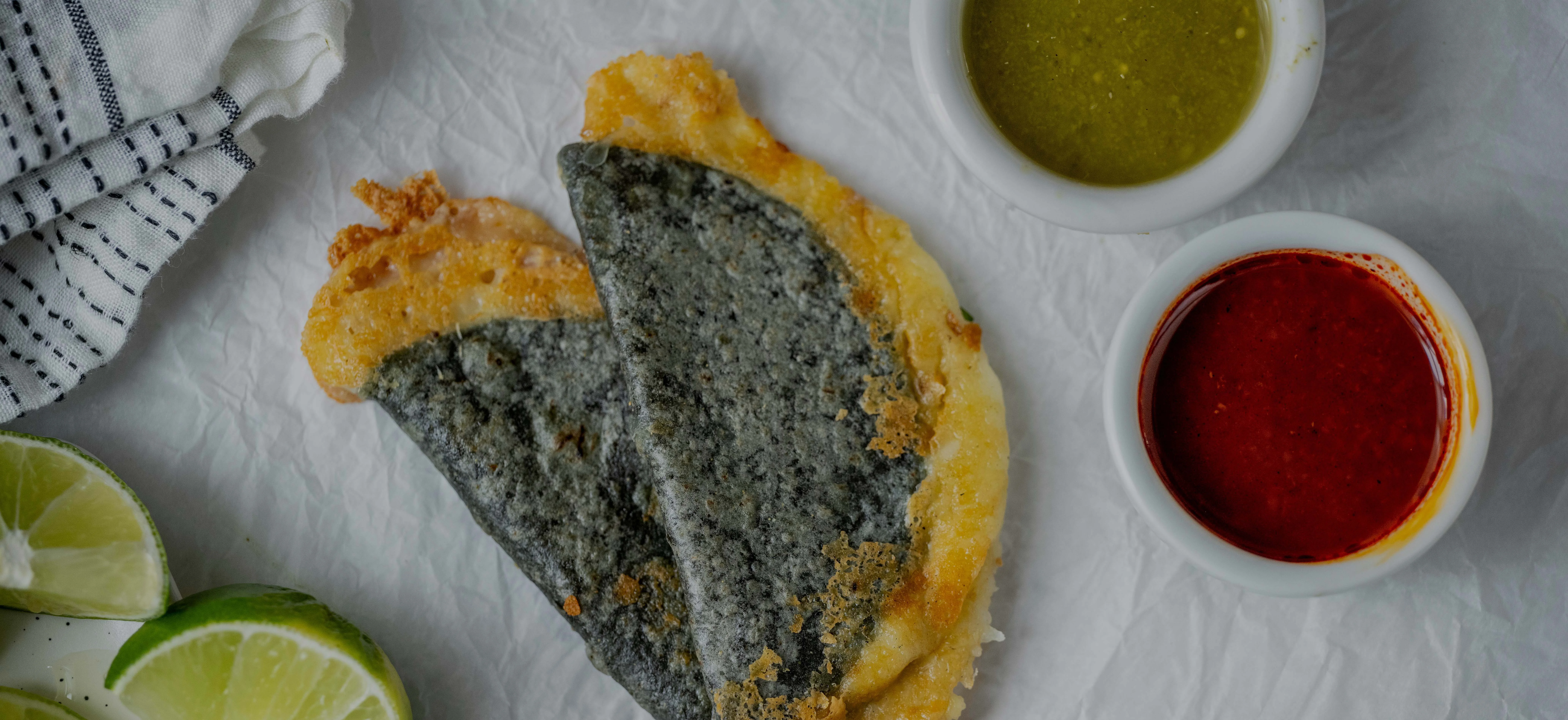Crispy Mexican quesadilla with salsas and lime wedges