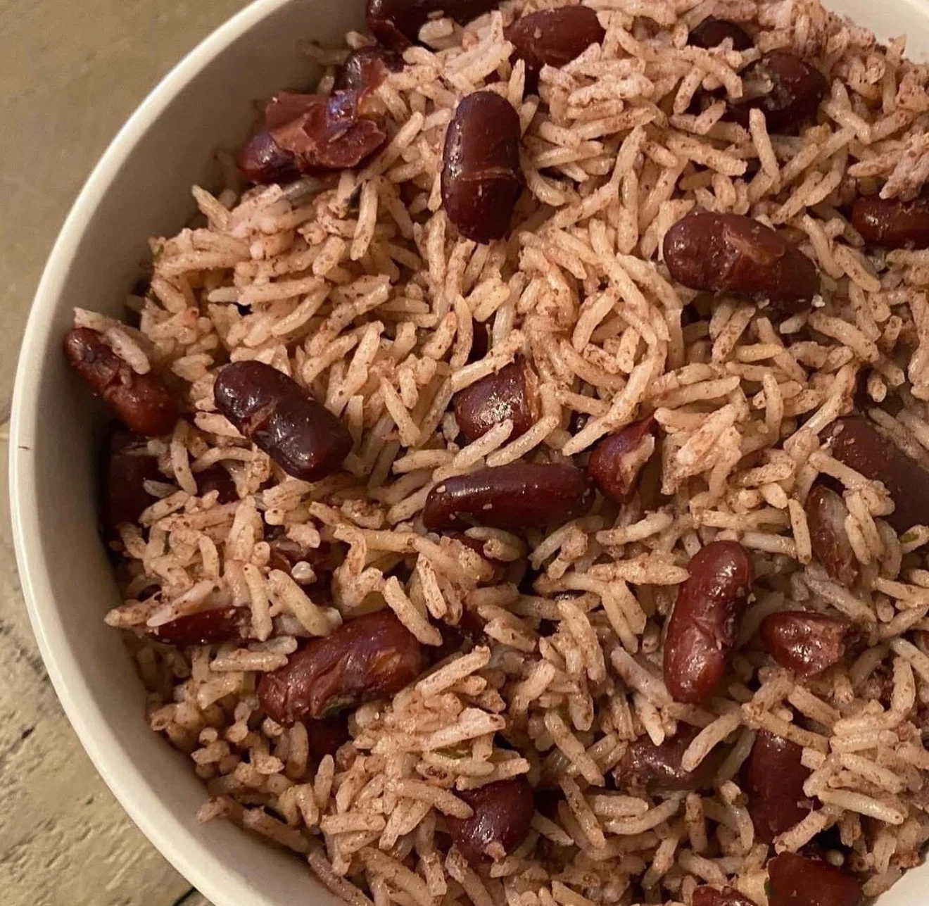 A bowl of rice mixed with red kidney beans, showcasing a fluffy texture.