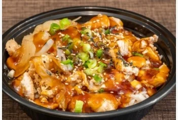 A black bowl filled with rice topped with shredded chicken, onions, green onions, and a savory sauce, garnished with sesame seeds.