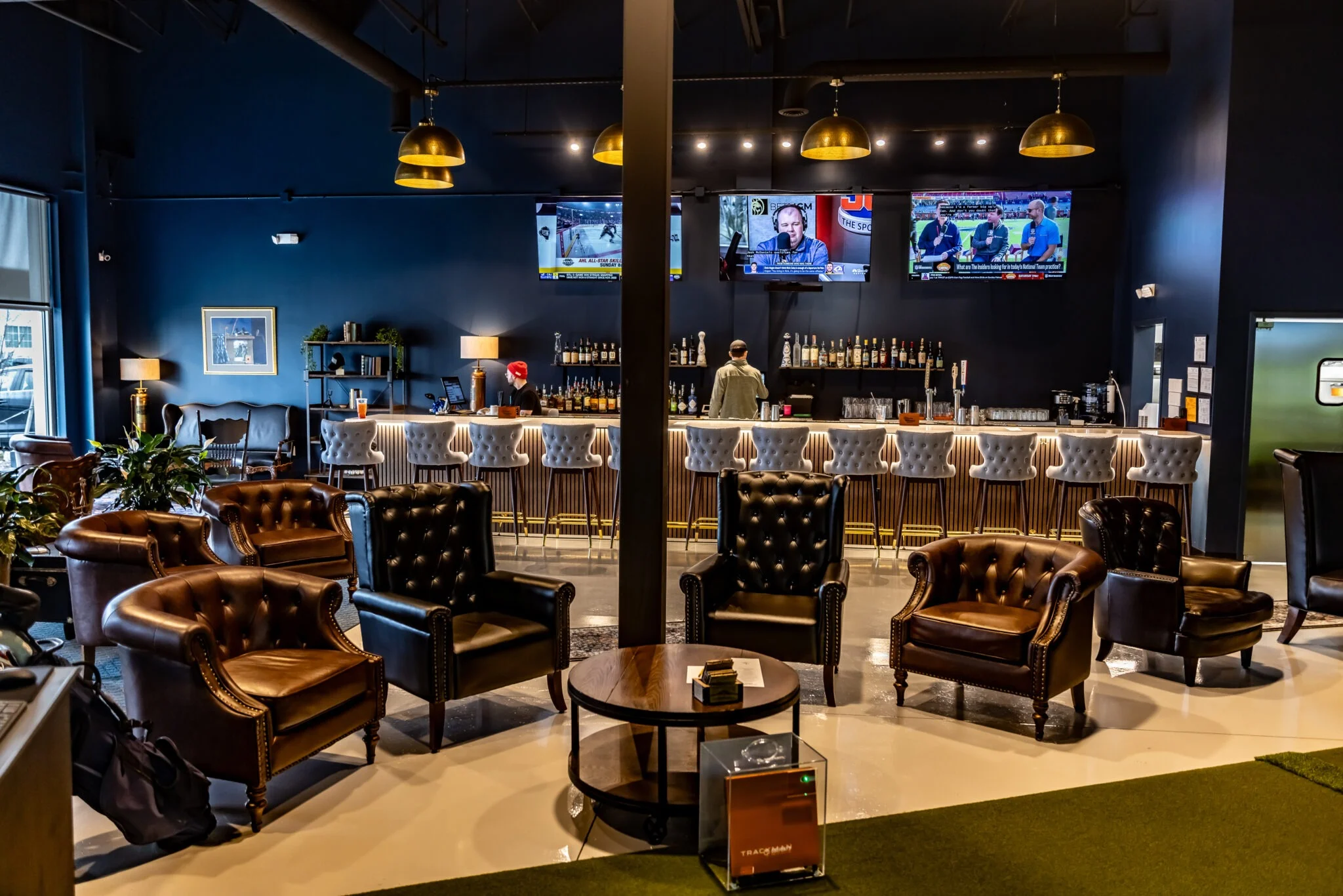 Modern bar interior with leather seating and multiple TVs