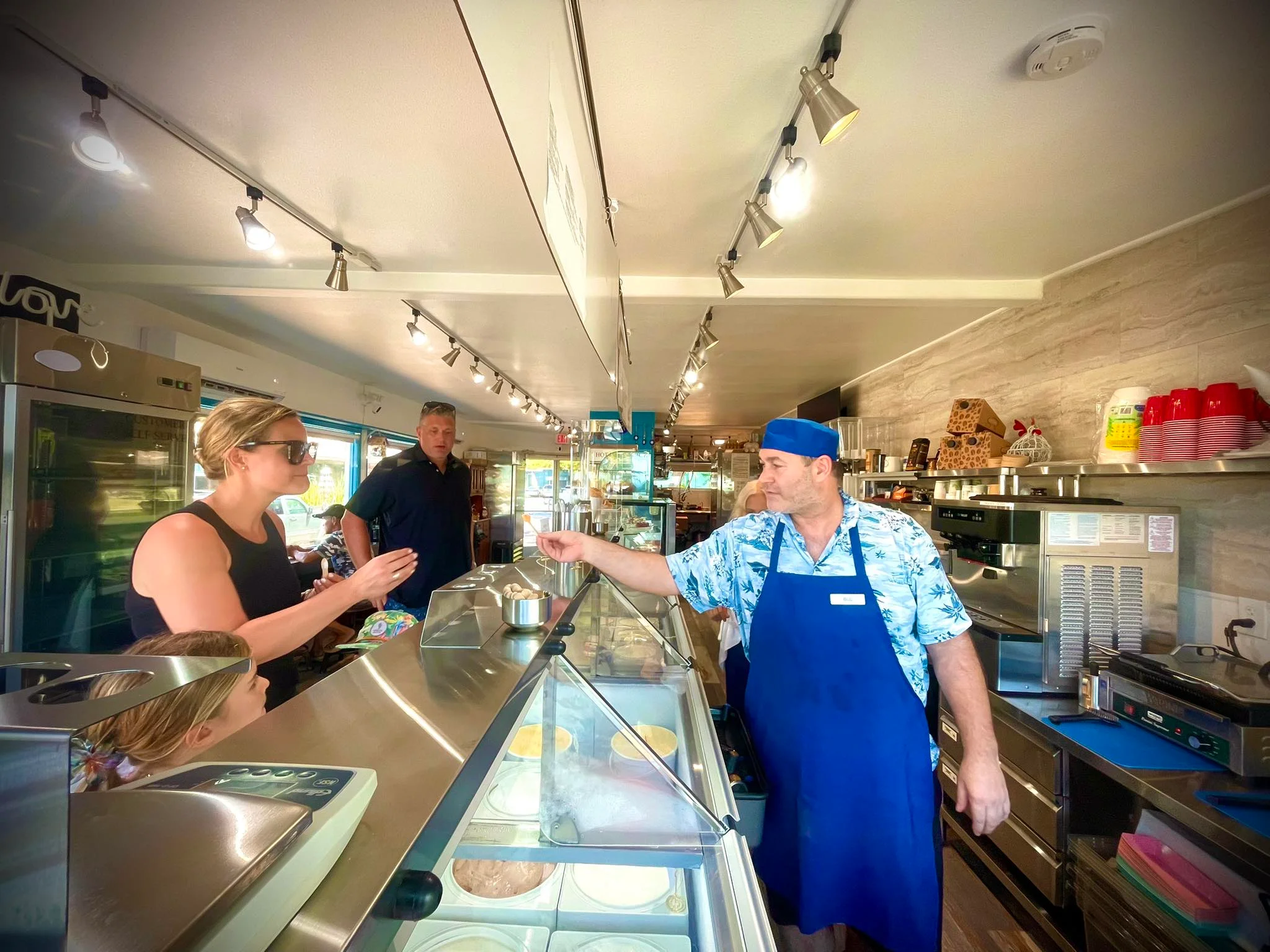 Ice cream shop with customers ordering treats