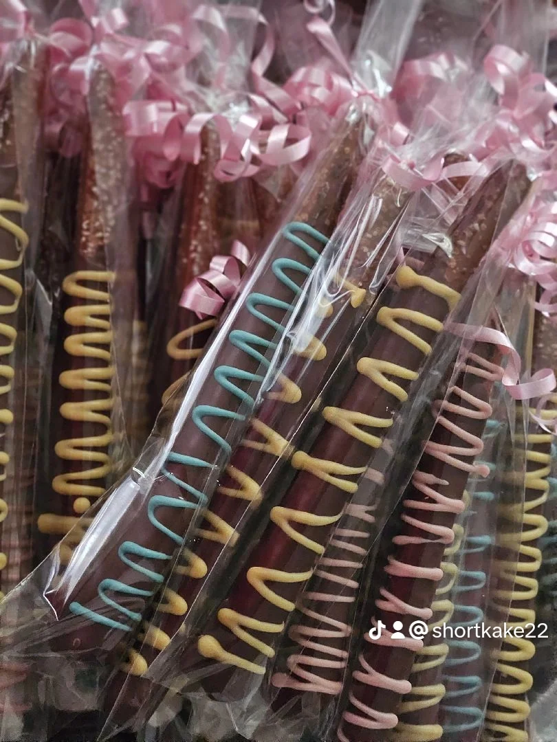 Colorful chocolate-covered pretzel rods with decorative icing