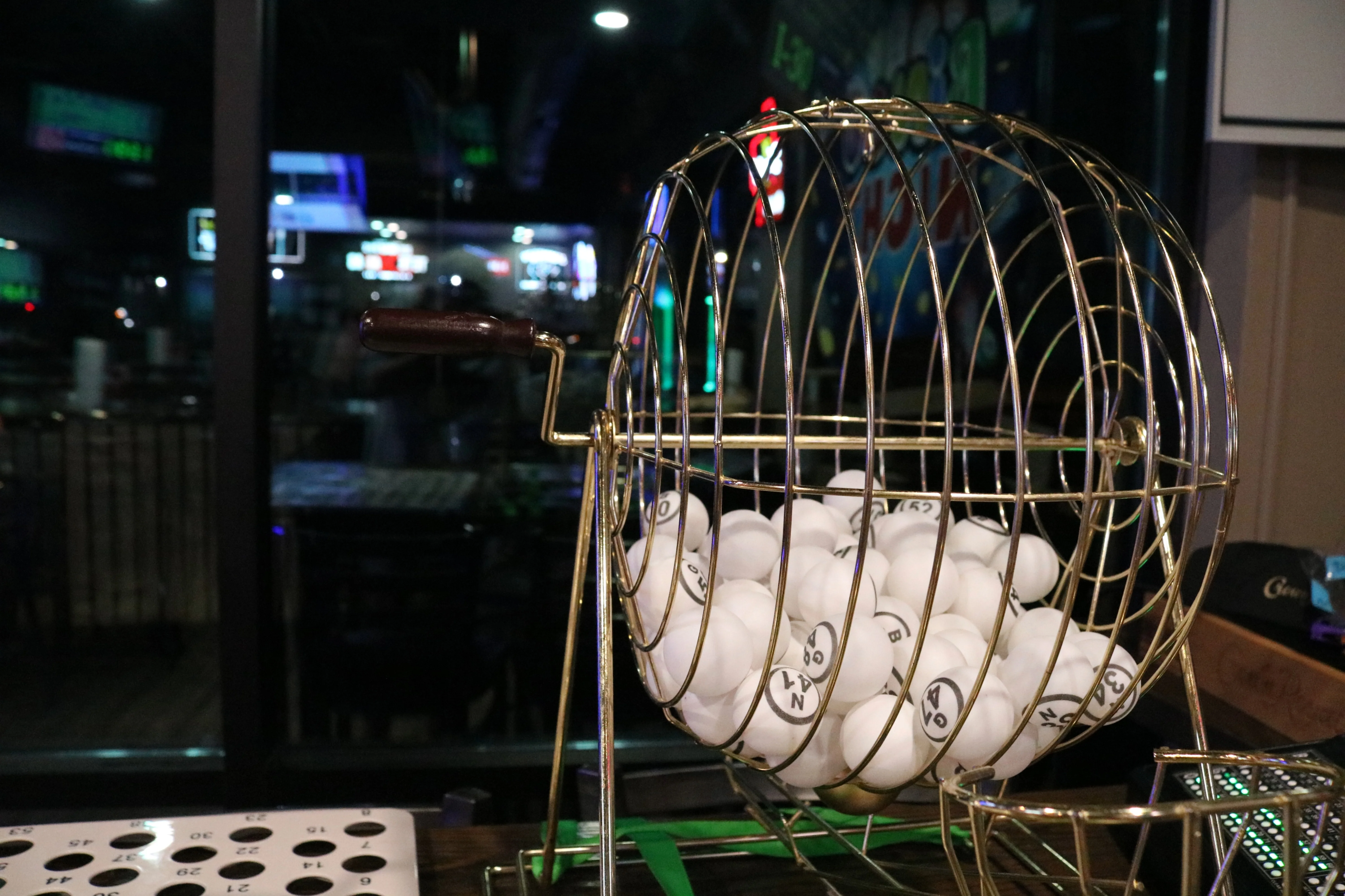 Bingo game setup with a gold cage and white balls