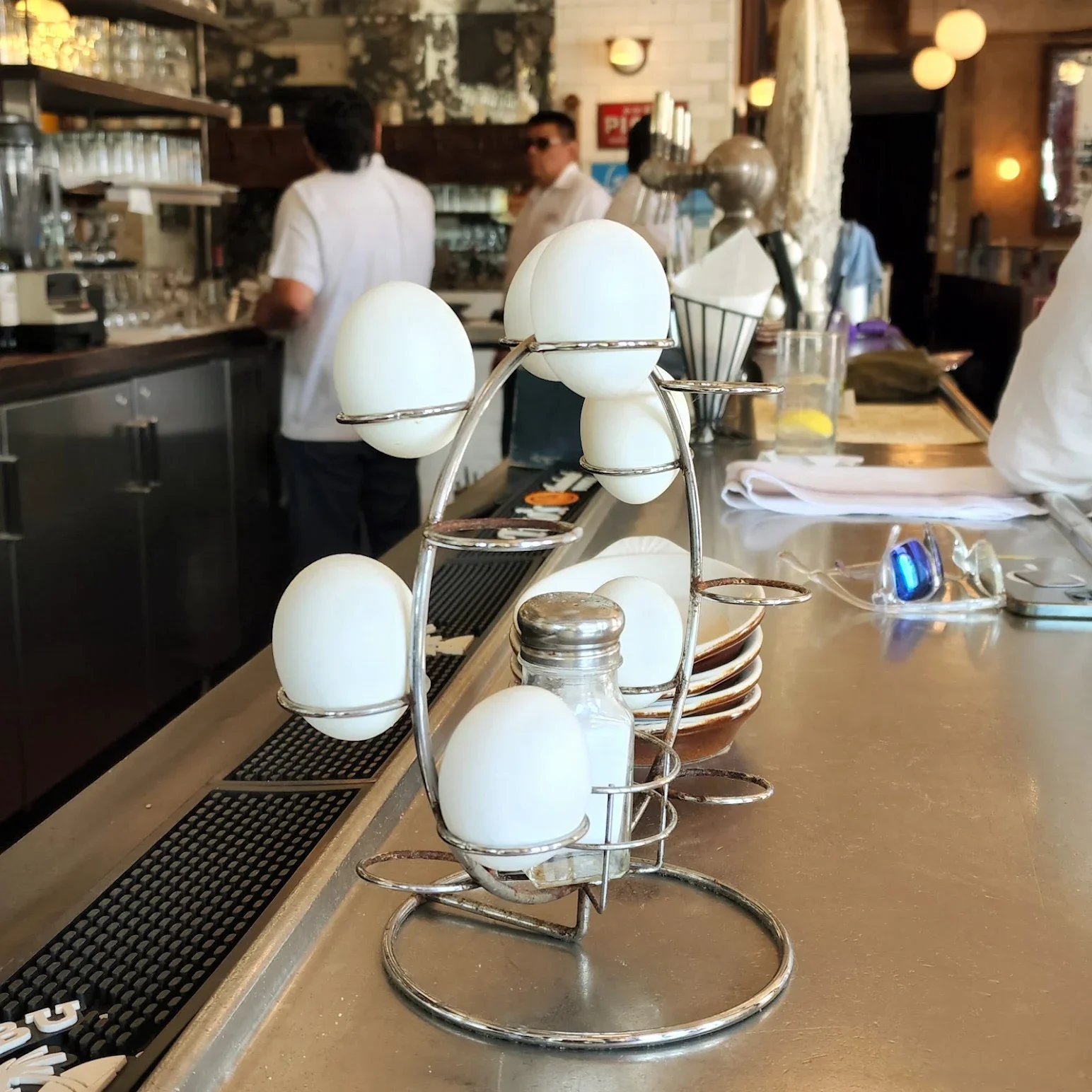 Unique egg holder display at a modern restaurant bar