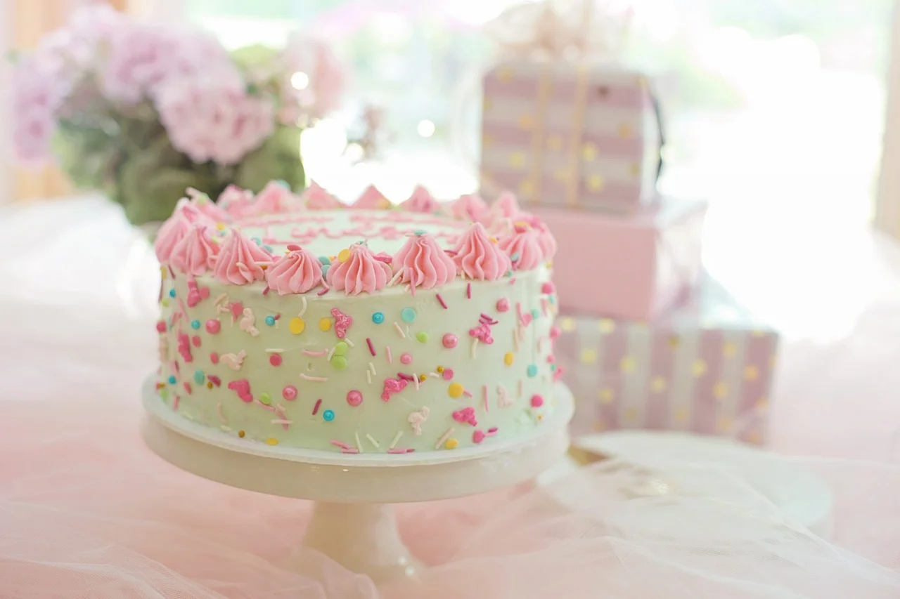 Colorful birthday cake with sprinkles and pink frosting