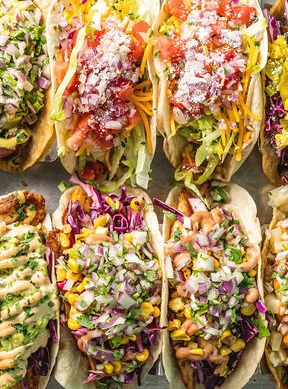 Colorful platter of Mexican street tacos with various toppings
