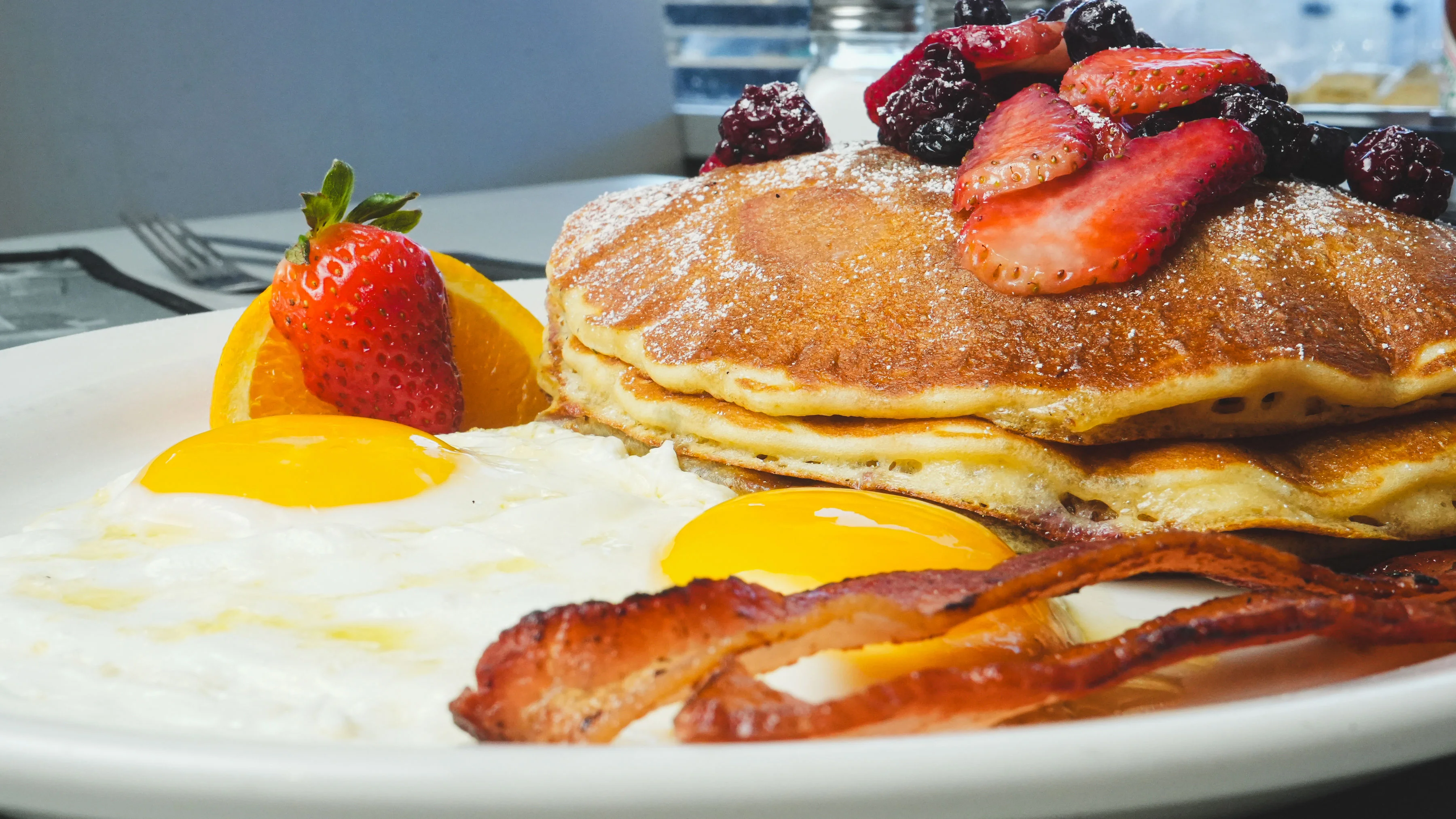Fluffy pancakes with eggs and bacon, classic American breakfast