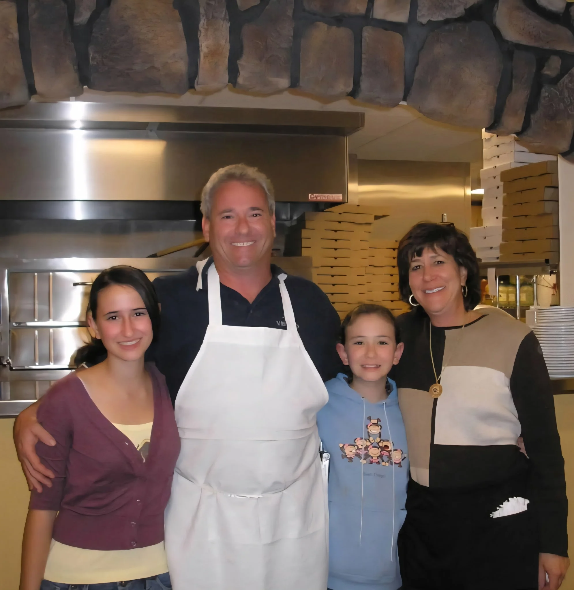 Family-owned restaurant team smiling in the kitchen