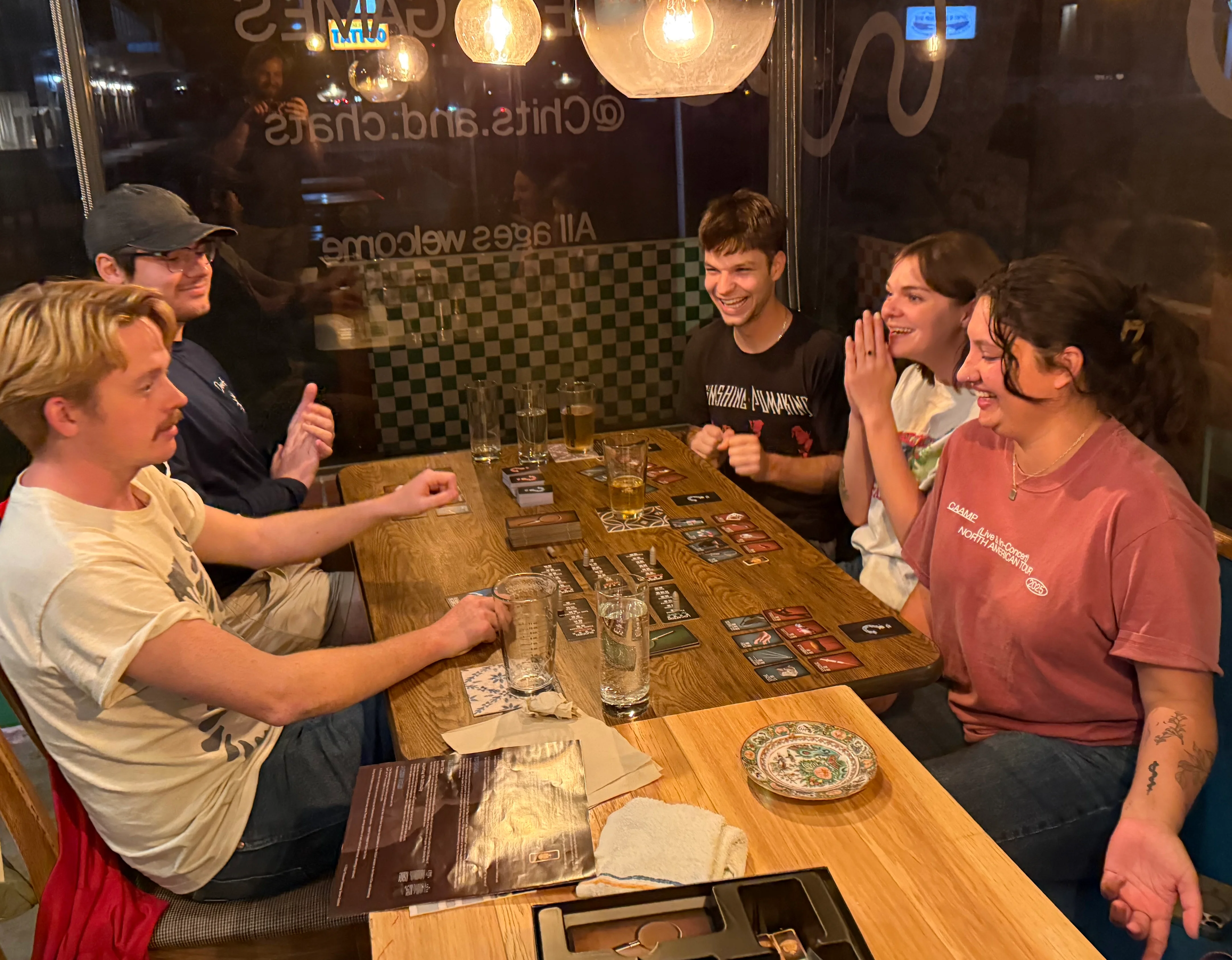 Group of friends enjoying board games in a cozy restaurant setting