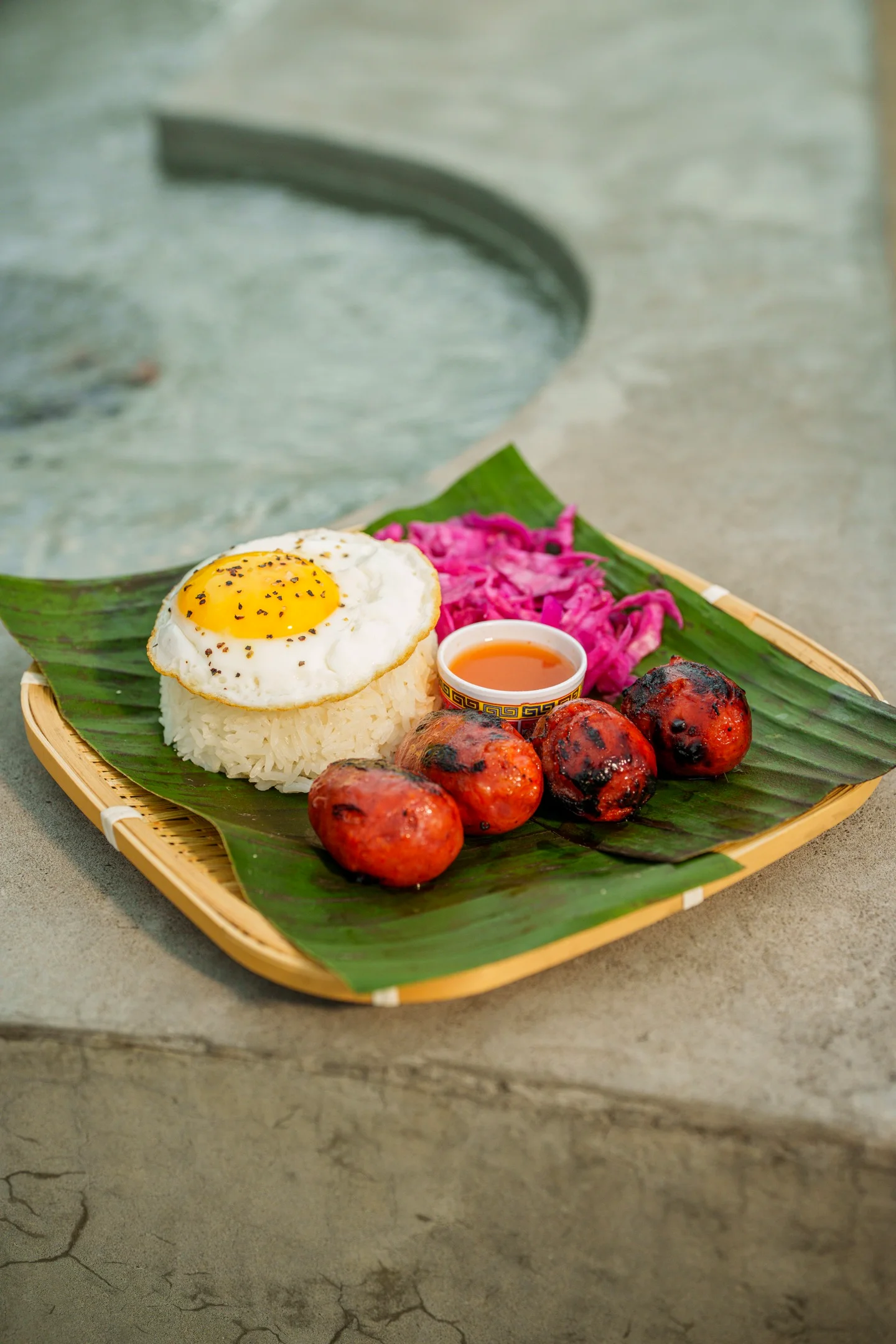 Filipino longganisa with rice and egg on a banana leaf platter
