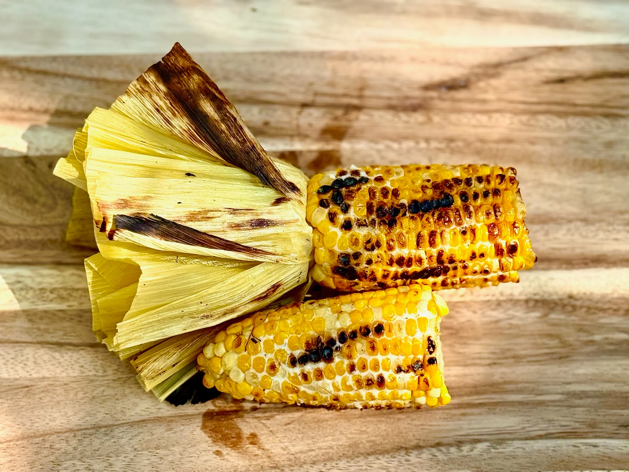 Grilled Mexican elote with corn husks