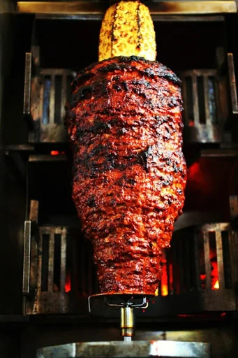 Authentic Mexican al pastor on a vertical spit with pineapple