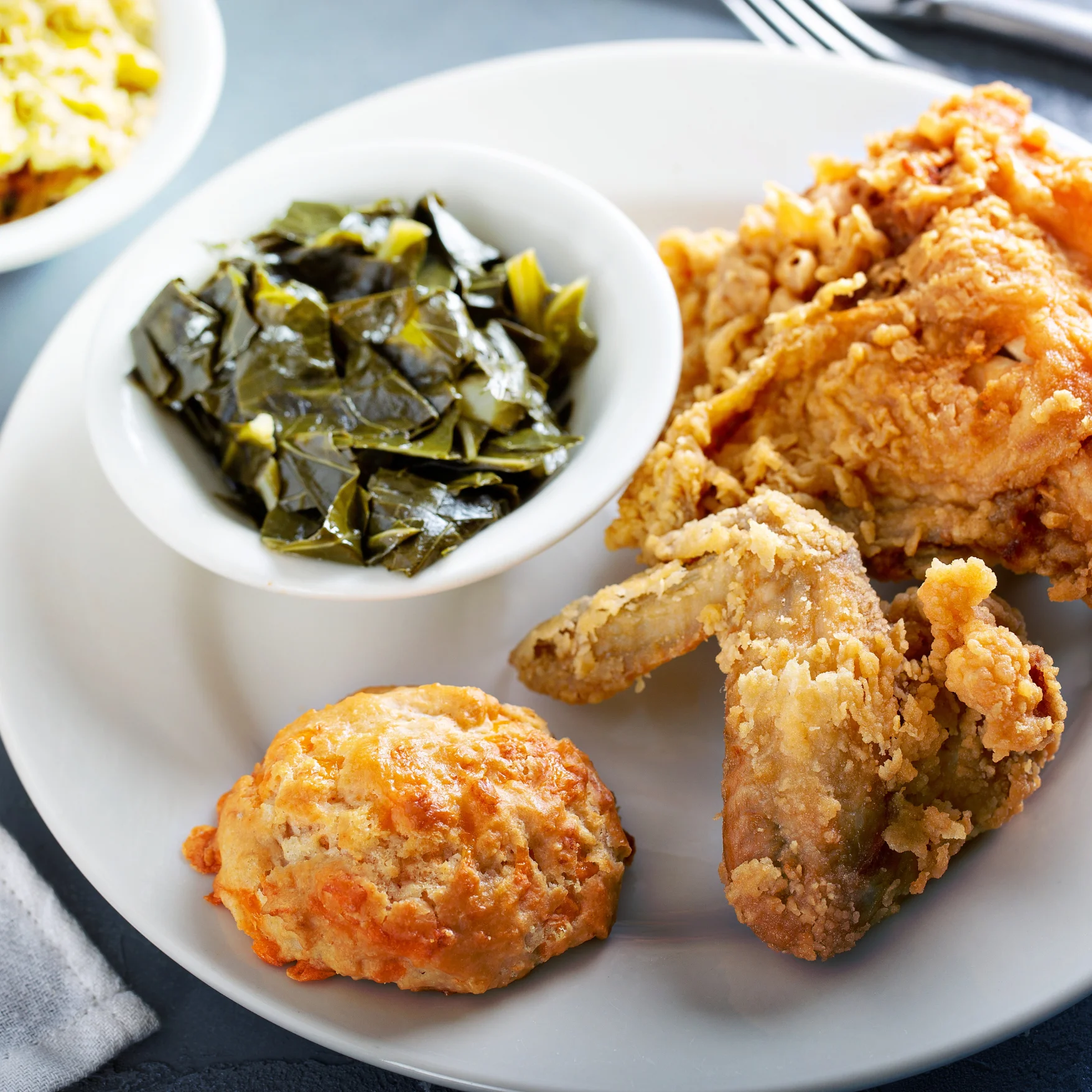 Southern fried chicken with collard greens and biscuit