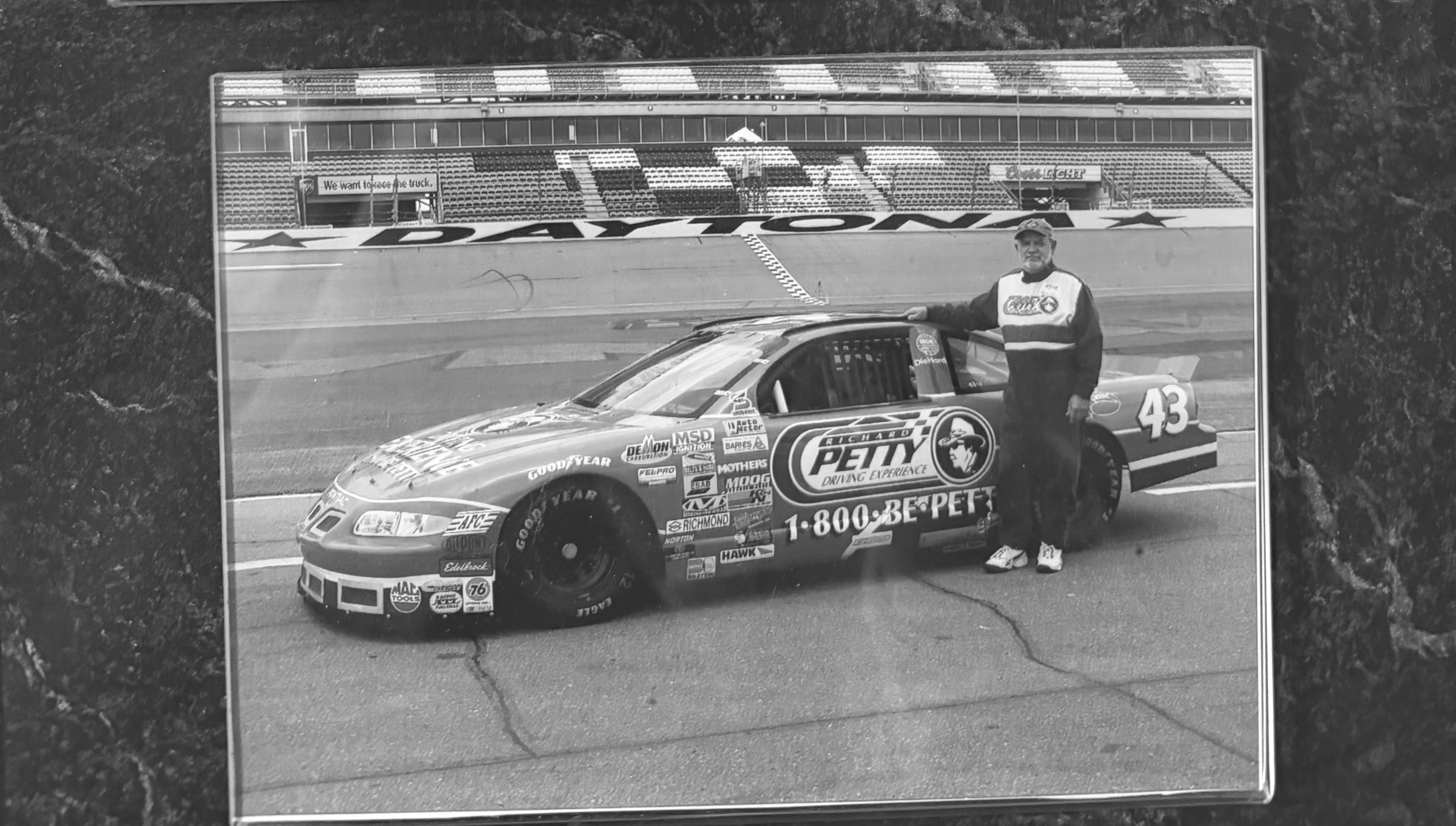 Black and white photos of a race car driver and a car at Daytona International Speedway.