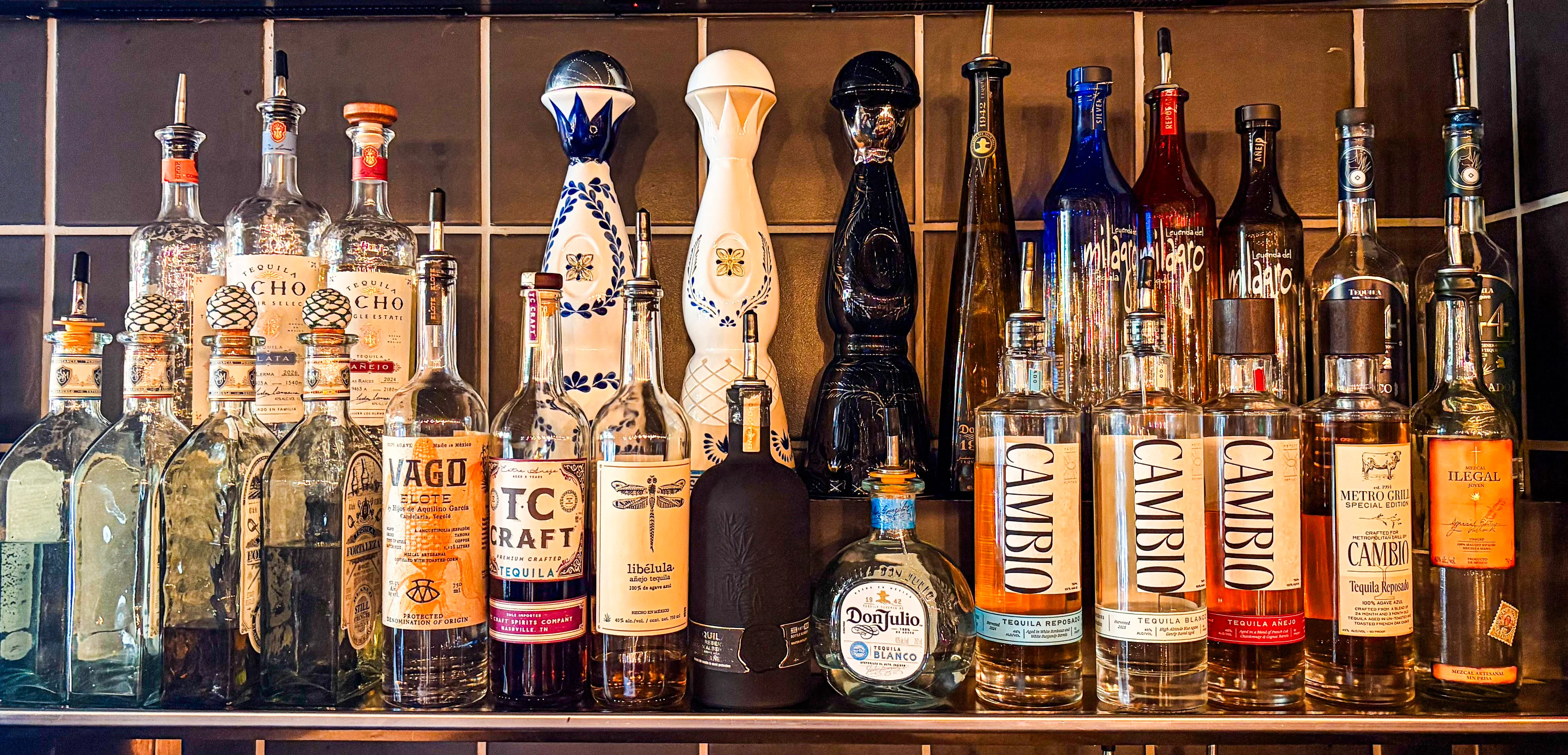 Variety of premium tequila bottles on a bar shelf