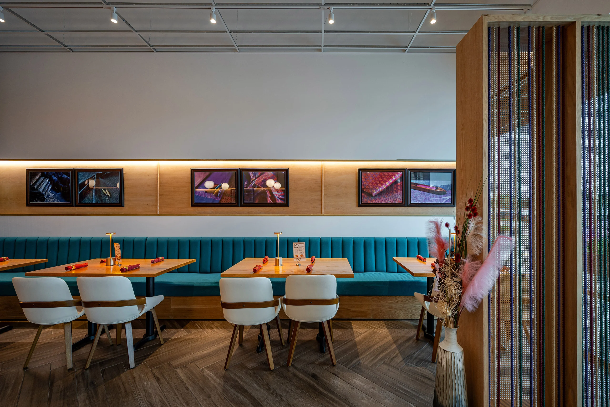 Modern restaurant interior with teal seating and artistic decor