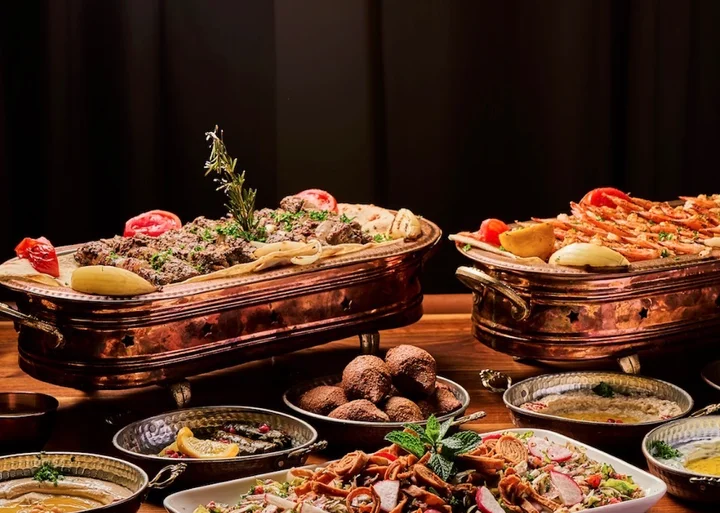 Jordanian feast with grilled meats, rice, falafel, hummus, baba ghanoush, and fresh salad.