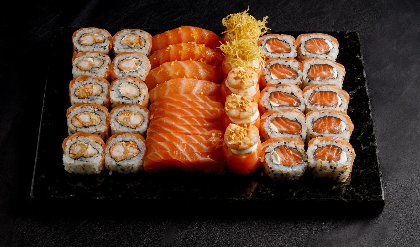 Assorted sushi platter featuring salmon and shrimp rolls