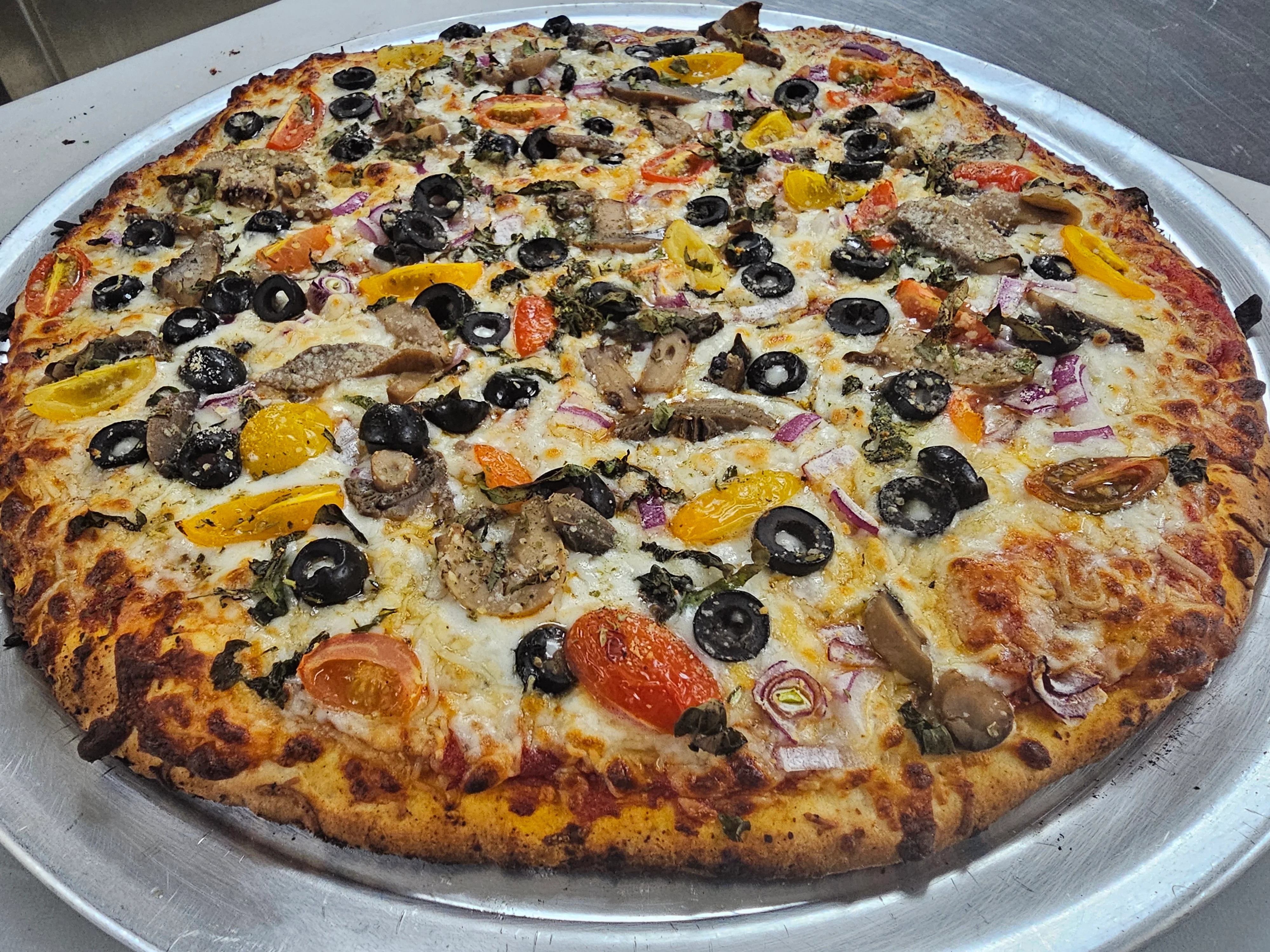 Vegetarian pizza topped with olives and colorful vegetables