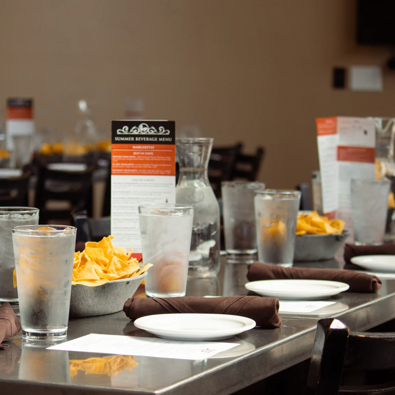 Cozy restaurant dining setup with water glasses and nachos