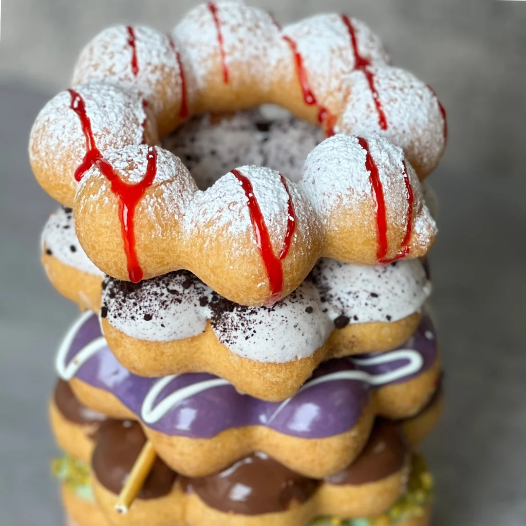 Colorful stack of gourmet donuts with various toppings