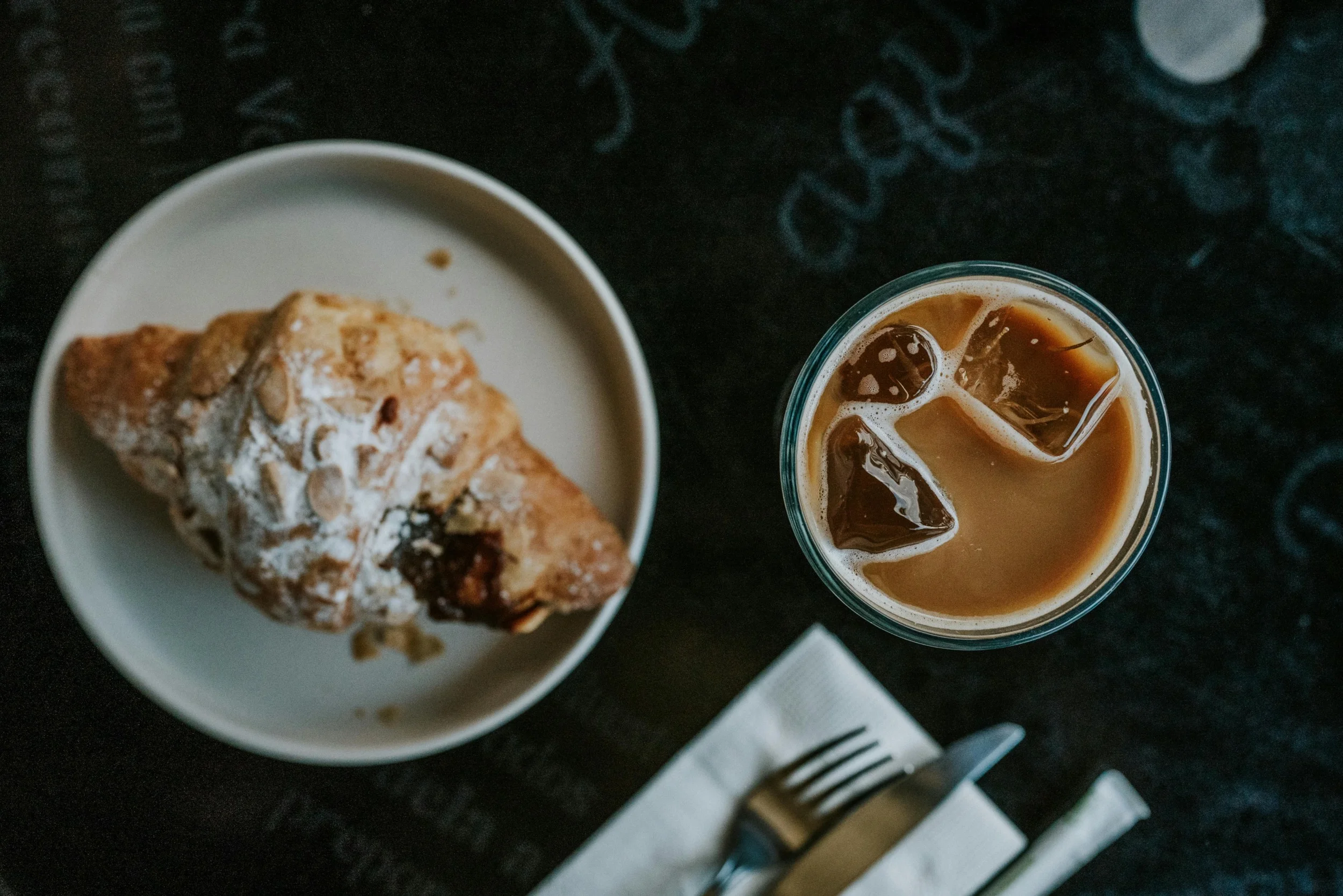 Freshly baked almond croissant with iced coffee
