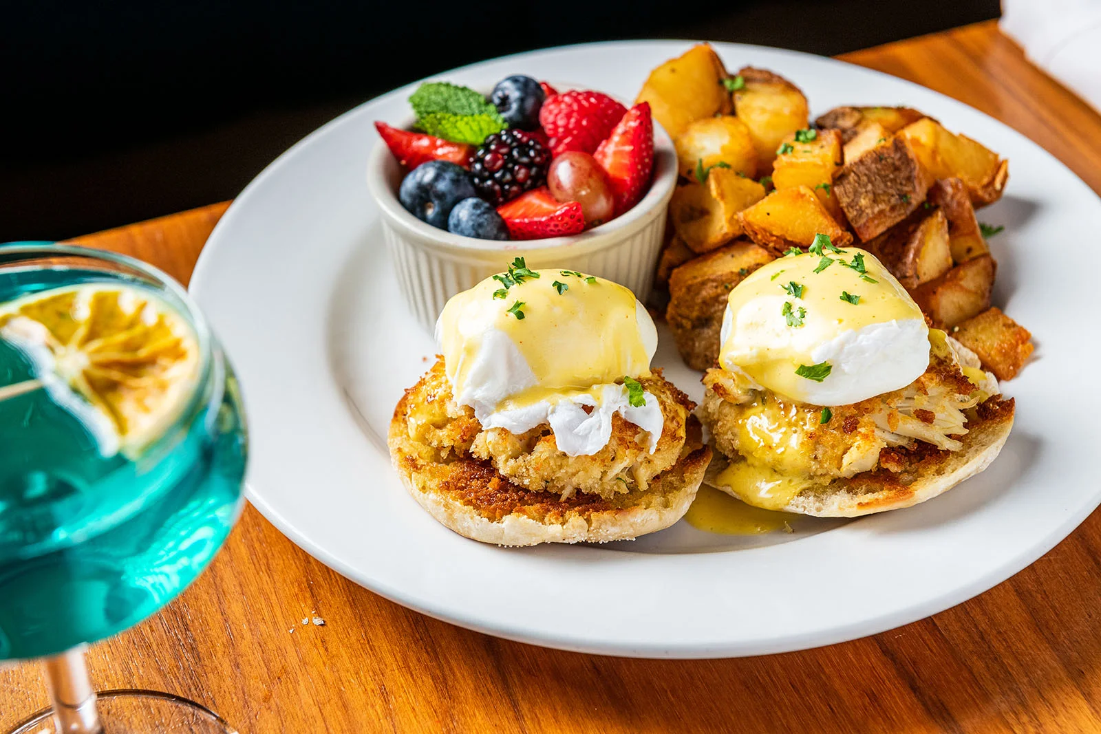 Crab cake eggs benedict with fresh fruit and roasted potatoes