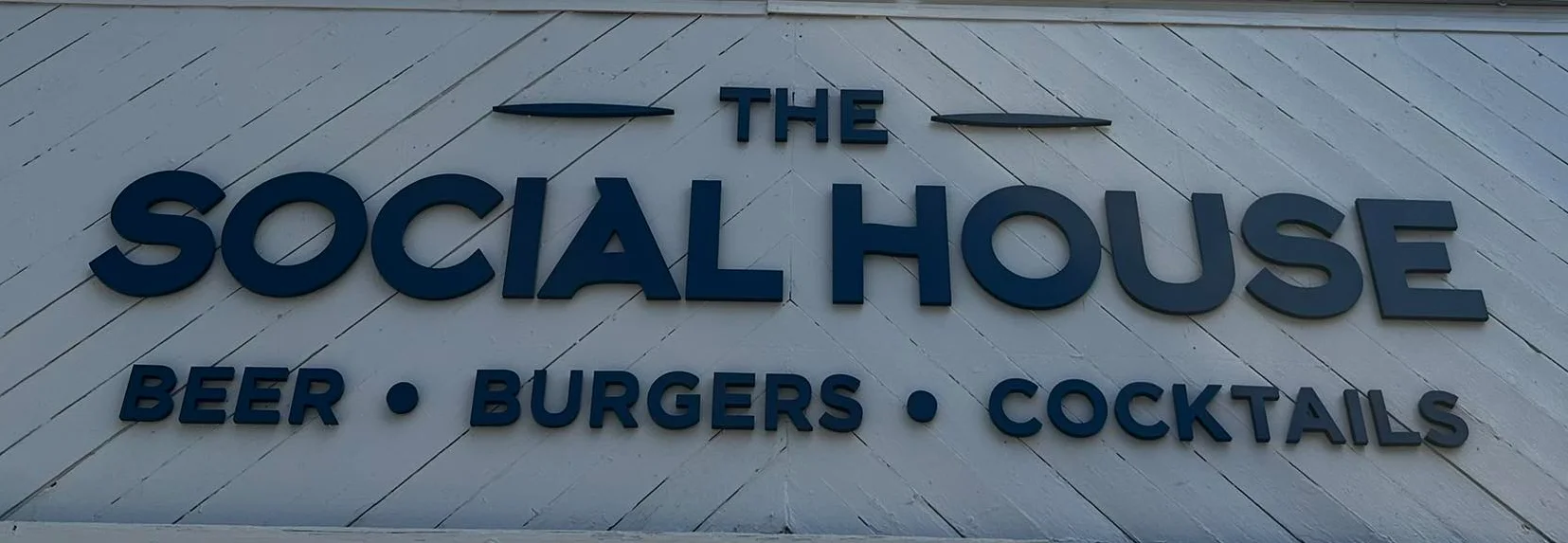 Exterior sign of The Social House featuring beer, burgers, and cocktails
