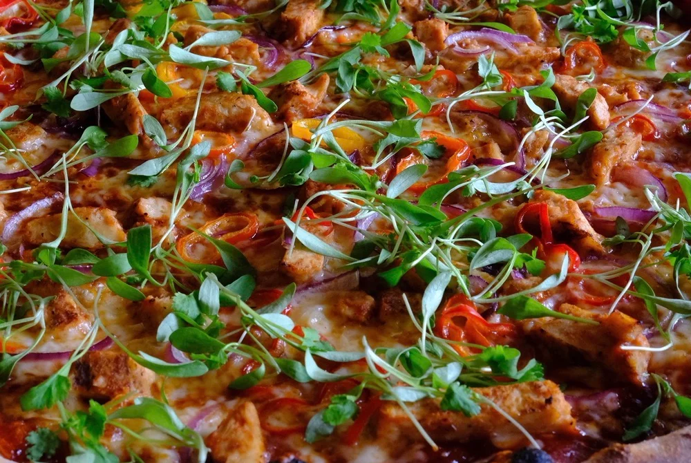 Chef serving a fresh Margherita pizza in a vibrant kitchen