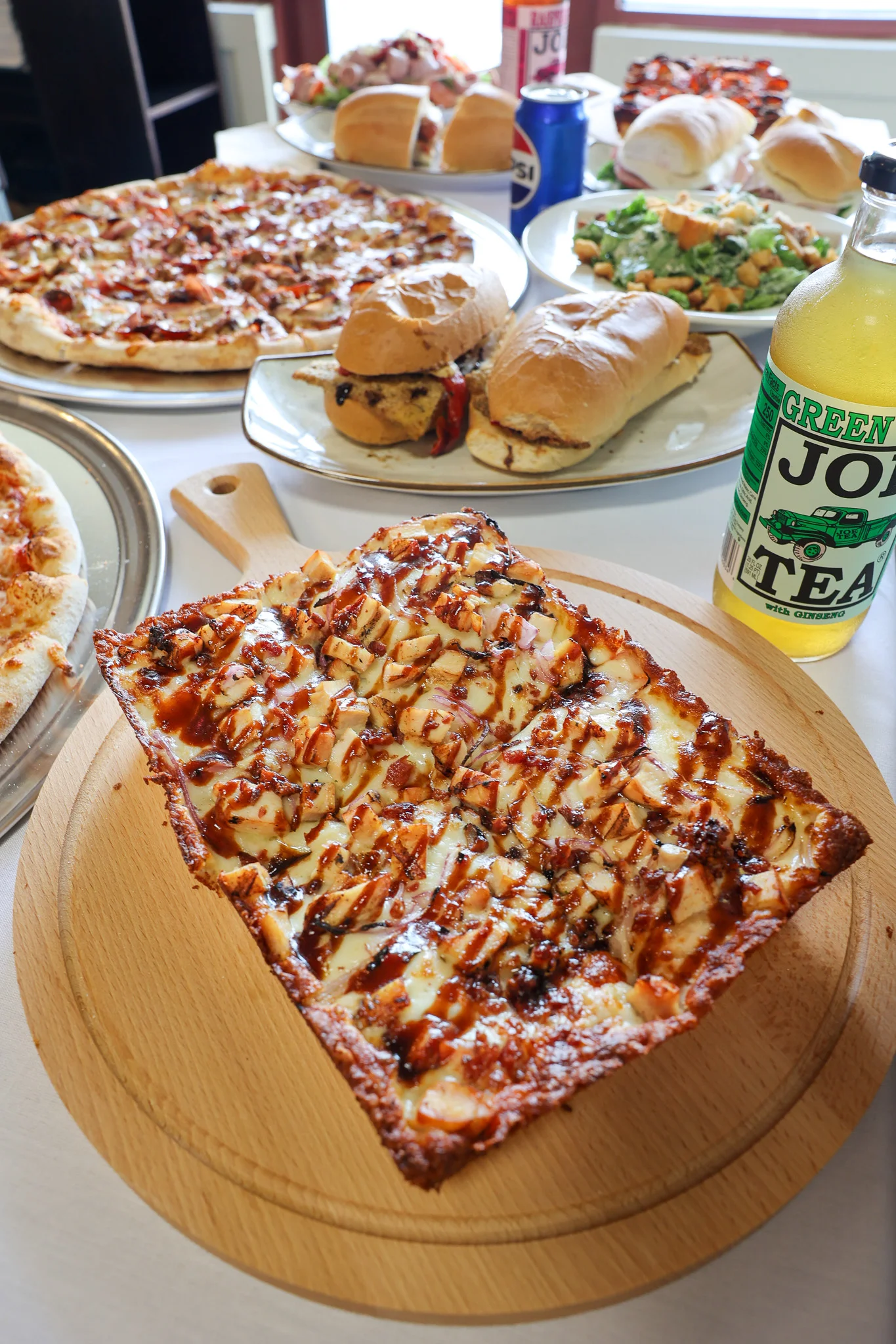 BBQ chicken pizza on a wooden serving board
