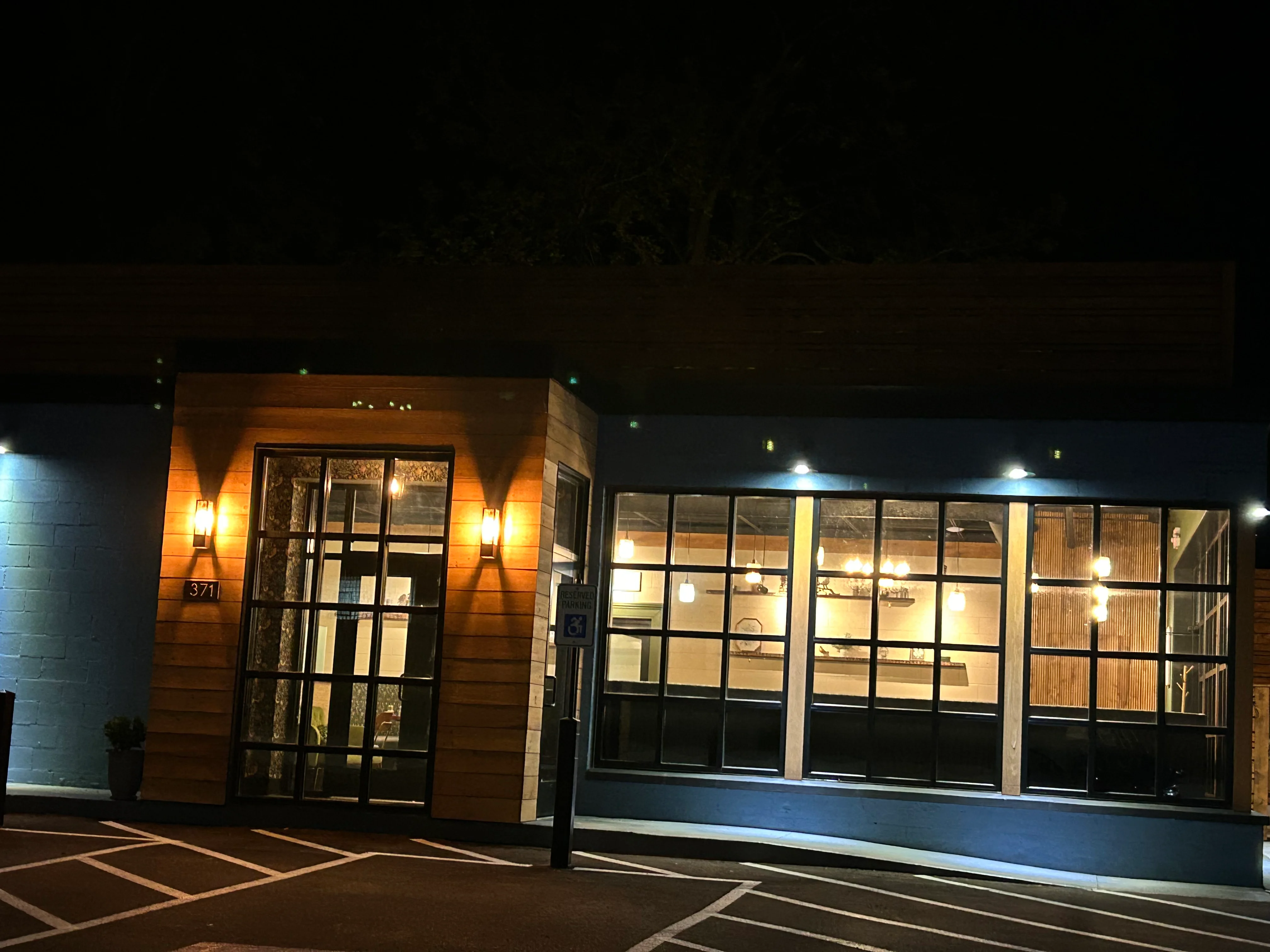 Modern restaurant exterior with warm lighting at night