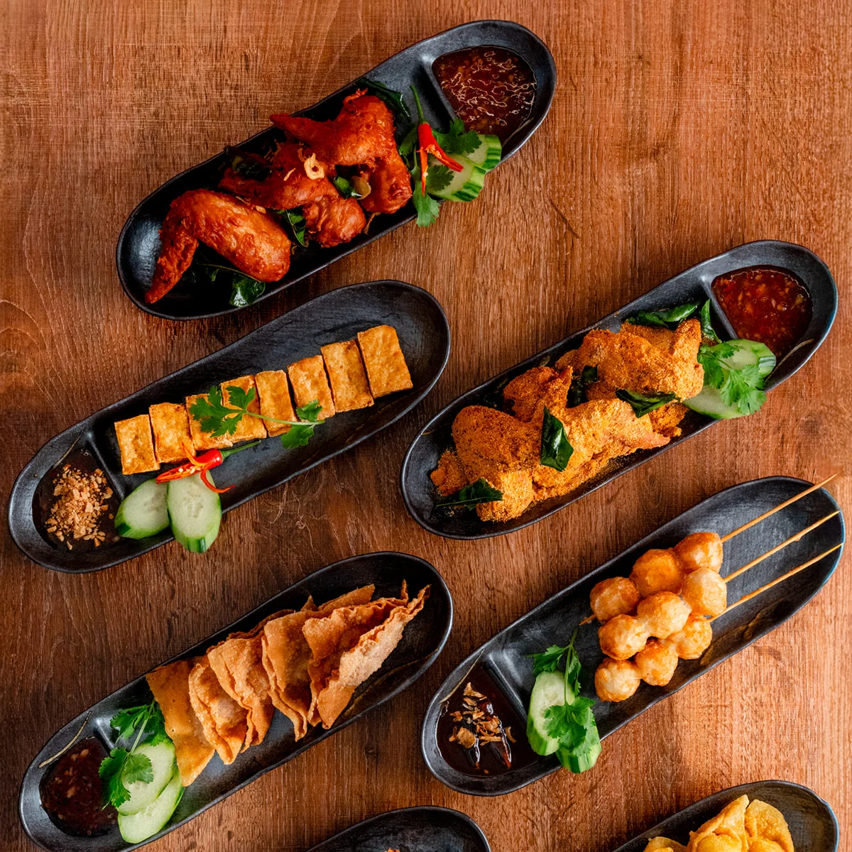 Assorted Asian appetizers including spring rolls and satay skewers