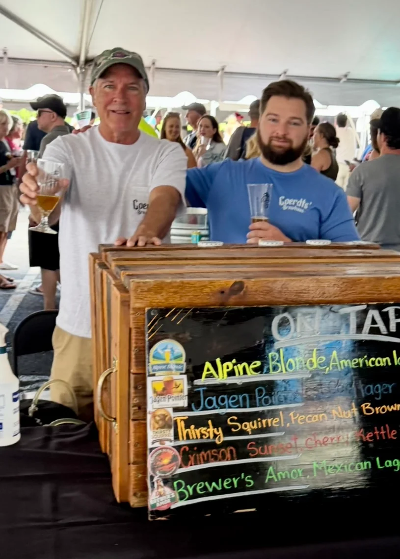 Craft beer booth at a festival with two smiling servers