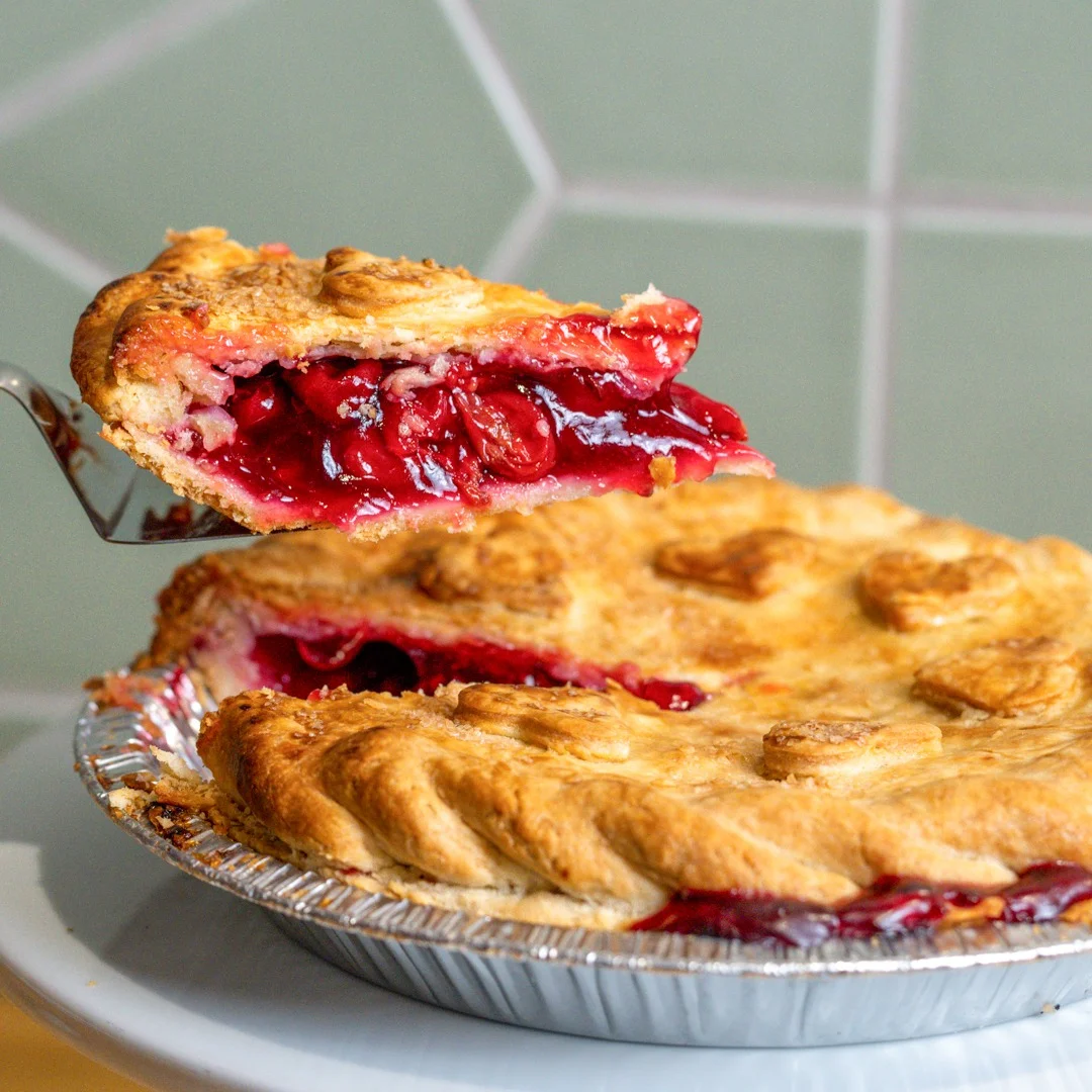 Assorted fruit pies on display at a dessert table