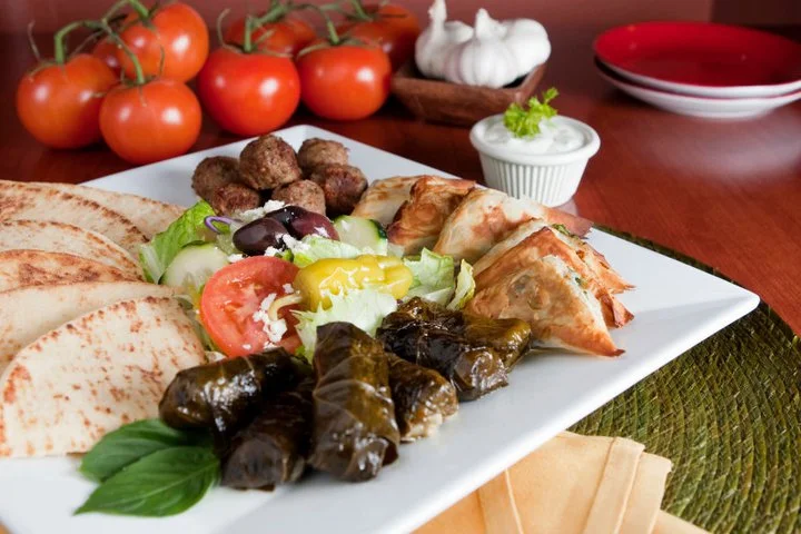 Delicious appetizer platter with various dips and garnishes.