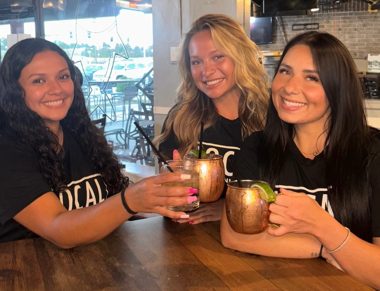 Three Local Staff Women Holding Up Drinks With Limes