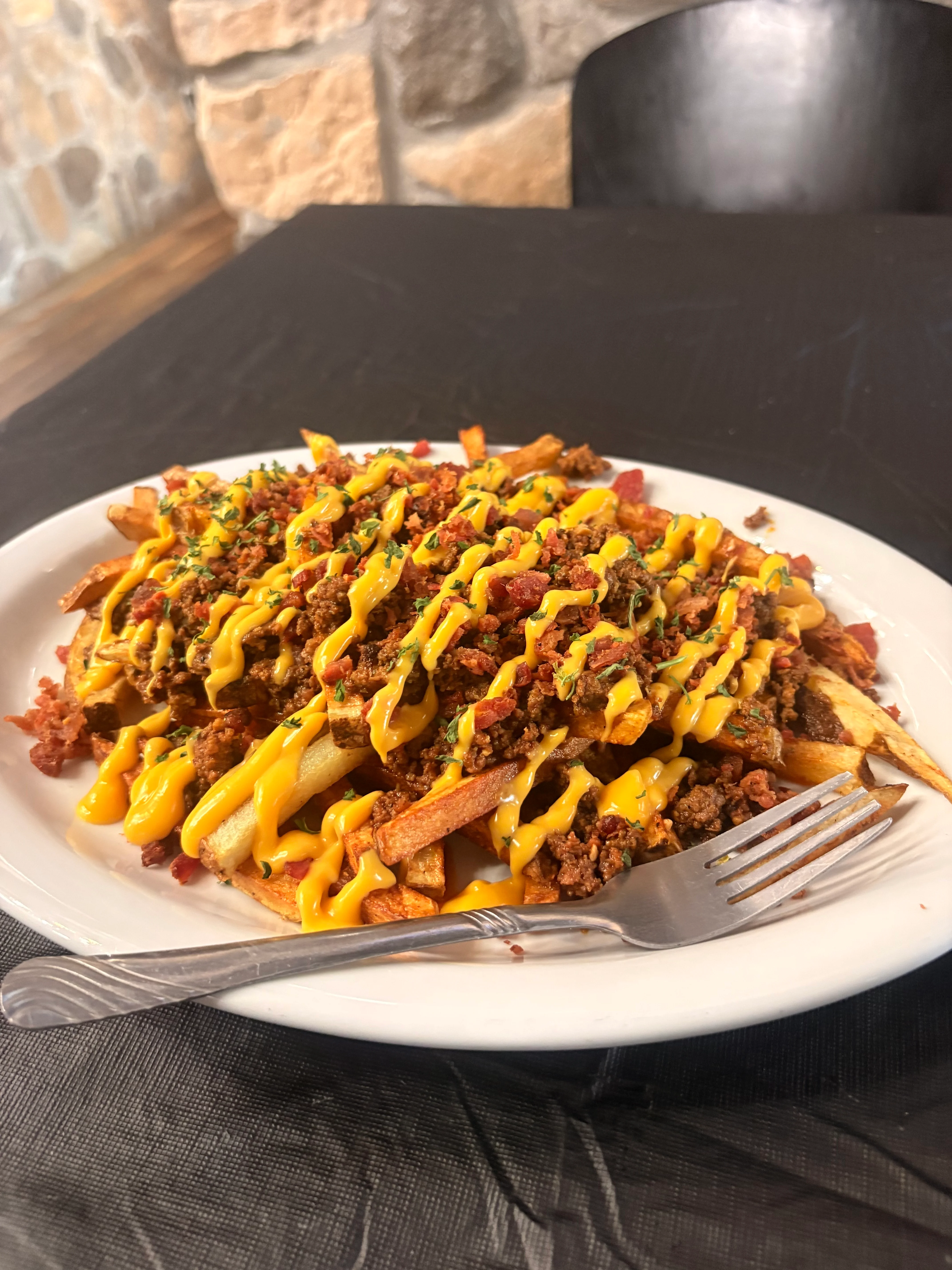 Loaded chili cheese fries served in a white plate
