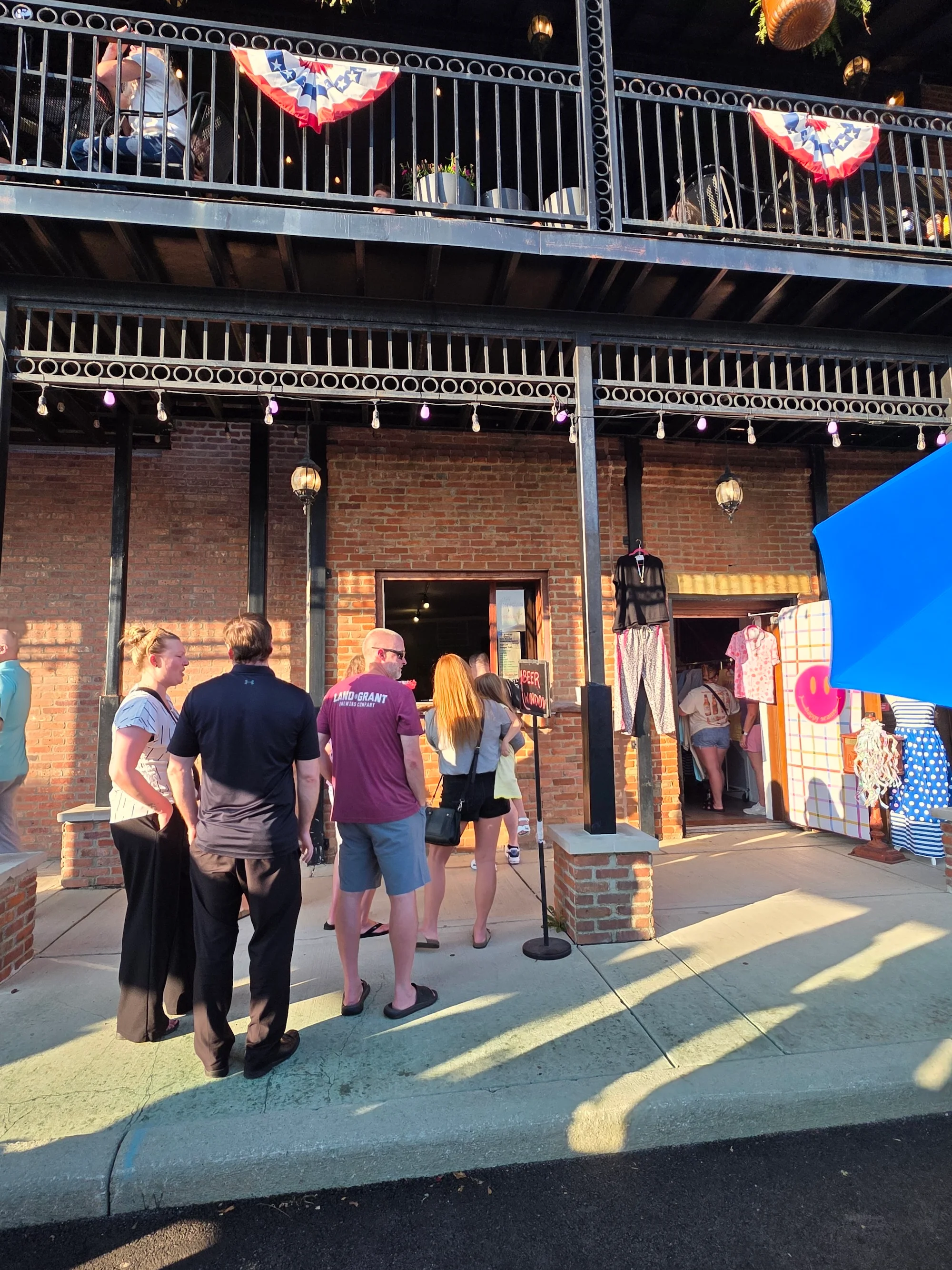 People waiting in line at the entrance of a building, with colorful decorations and a welcoming ambiance.
