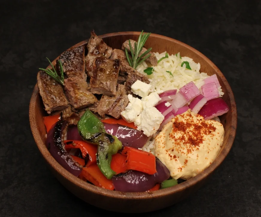 Mediterranean grilled beef bowl with hummus and vegetables