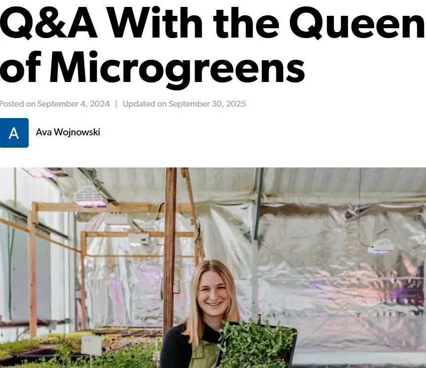 Person holding microgreens in a greenhouse setting