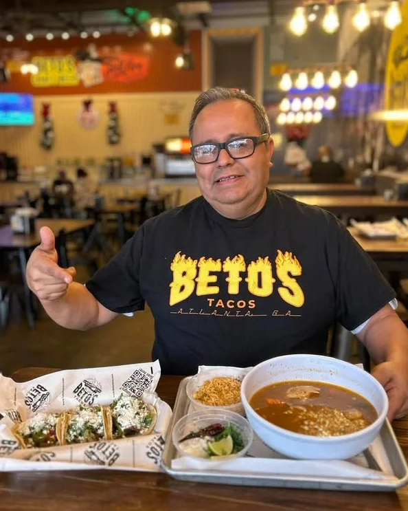 Customer enjoying tacos and soup at Betos Tacos restaurant.