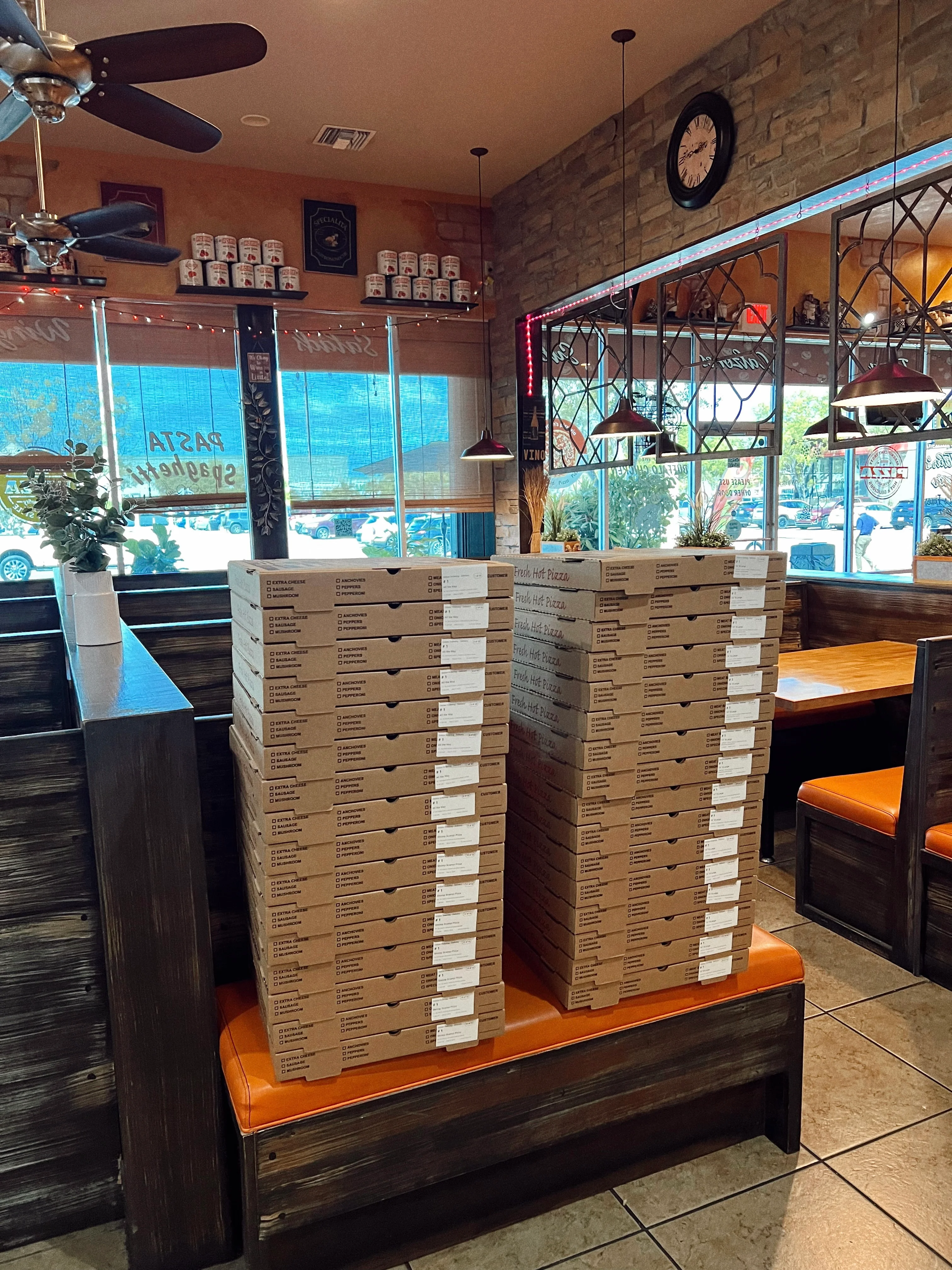 Stack of pizza boxes in a cozy restaurant interior