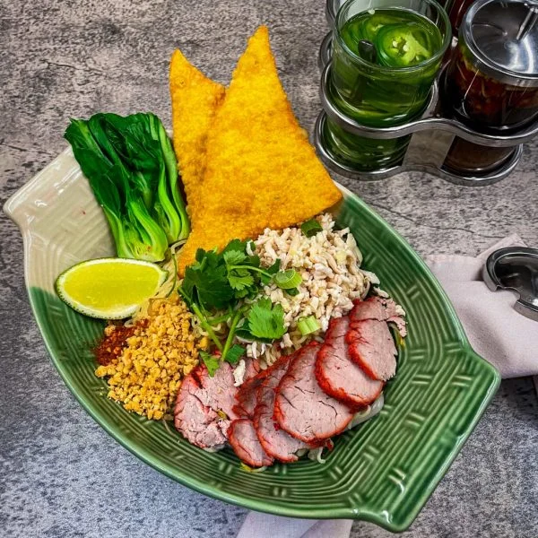 Thai rice noodle dish with roasted pork and fresh vegetables
