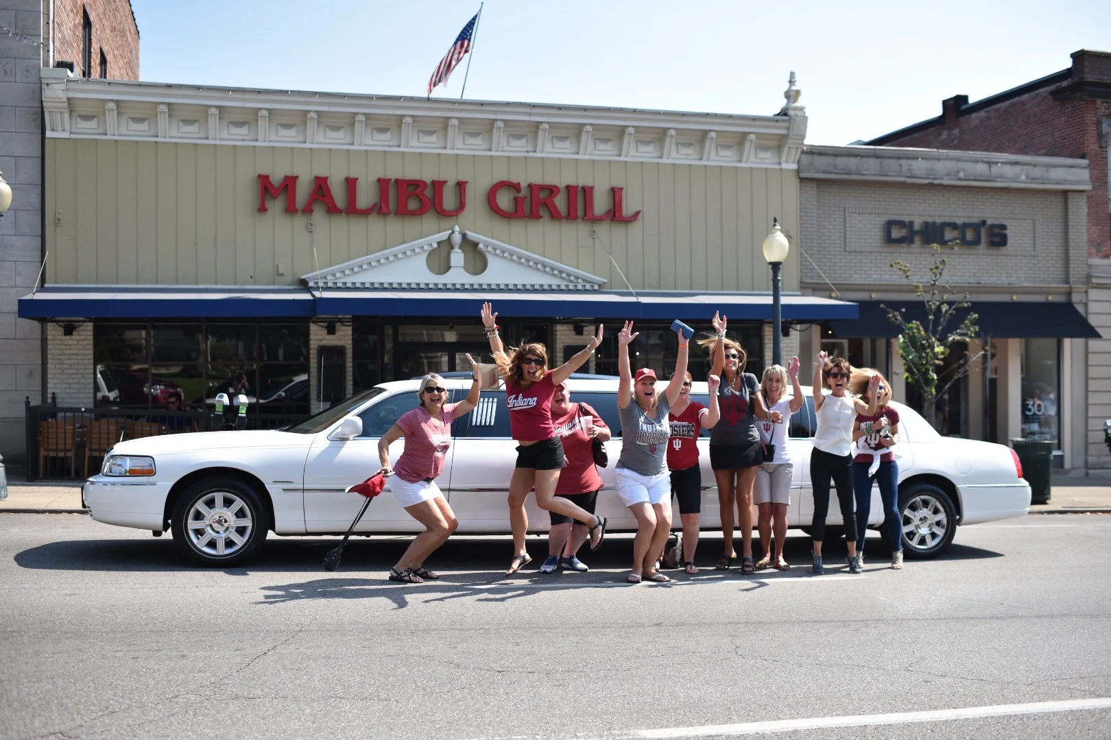 Group of friends celebrating outside Malibu Grill restaurant