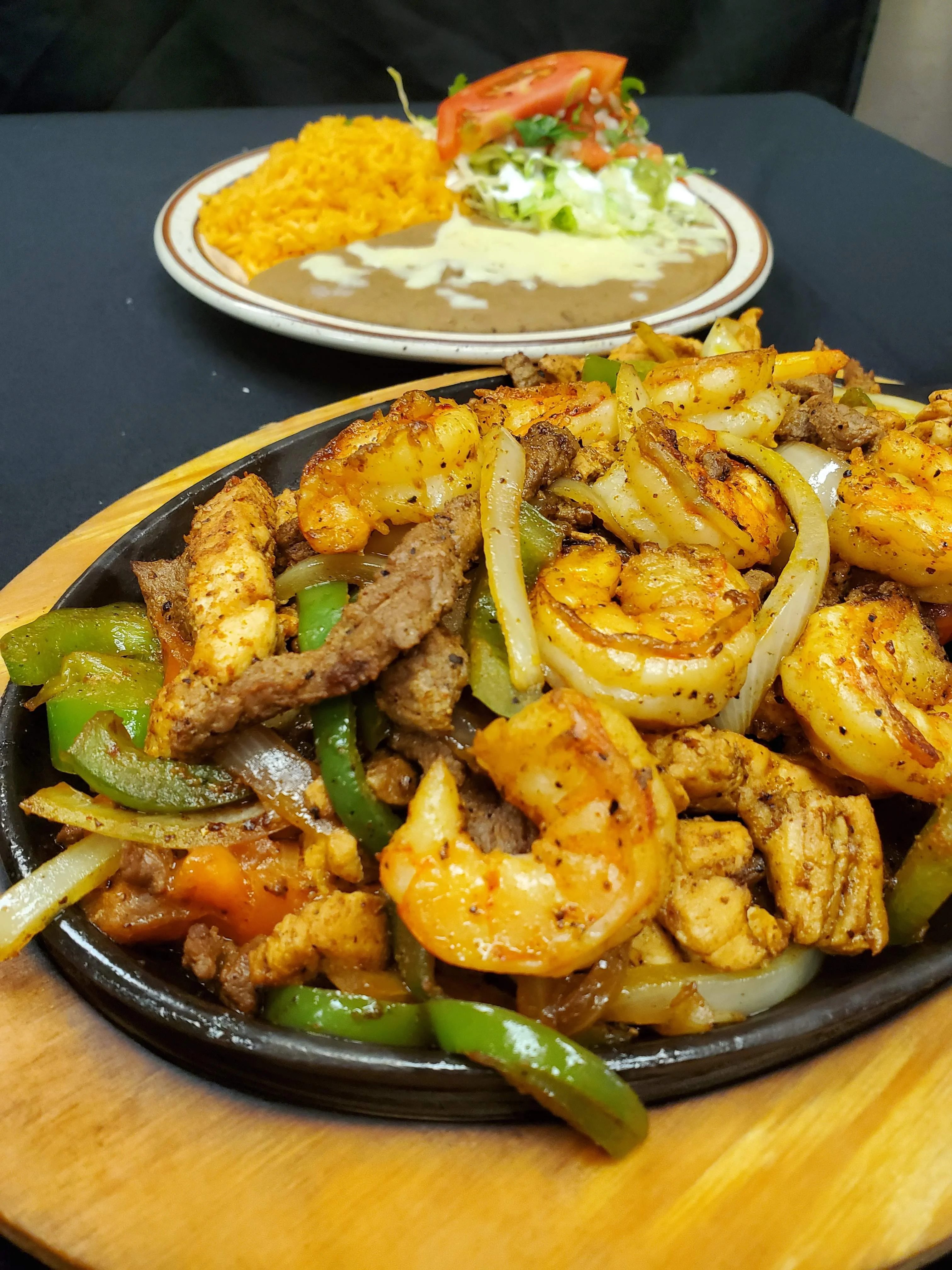 The Best Texas Fajitas in Radford. The best fajita texanas in Radford. Sizzling Texas Fajitas with marinated grilled chicken, tender beef, and succulent shrimp, served with sautéed bell peppers,tomatoes and onions on a hot skillet, accompanied by a plate of Mexican rice, refried beans, fresh salad, guacamole, Pico de Gallo and a slice of tomato.