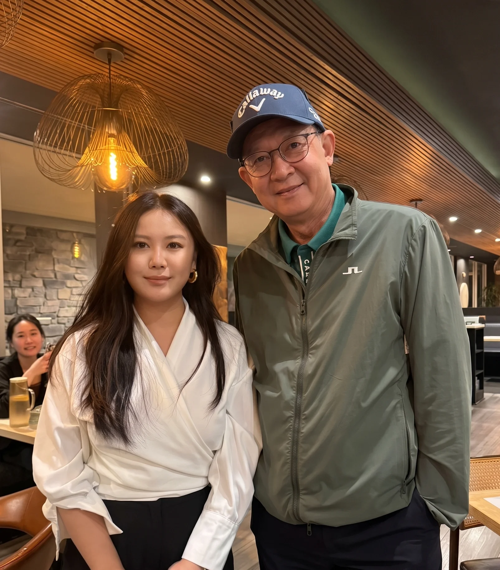 Two people posing in a modern restaurant with warm lighting
