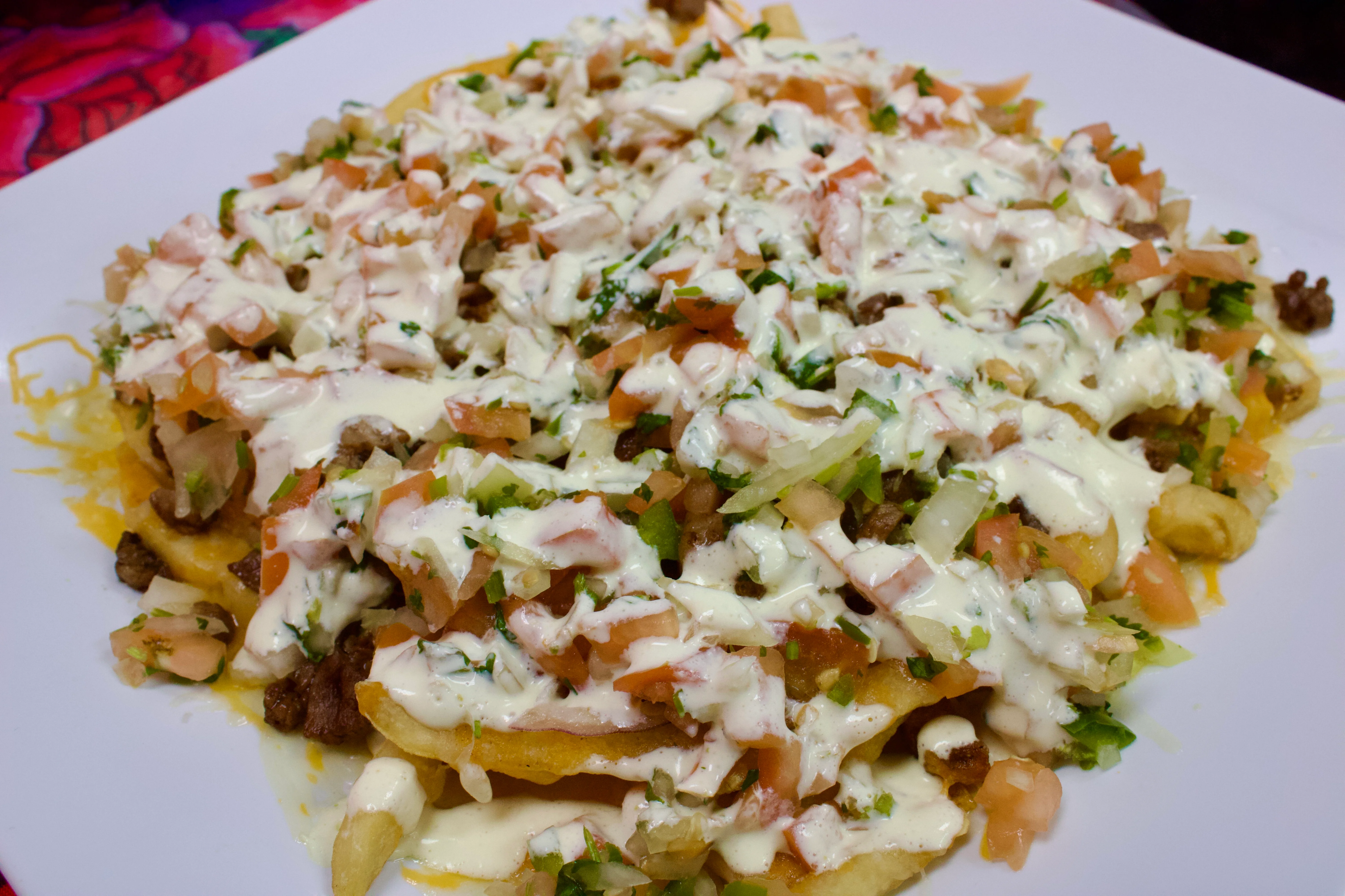 Loaded Mexican nachos topped with meat and fresh toppings