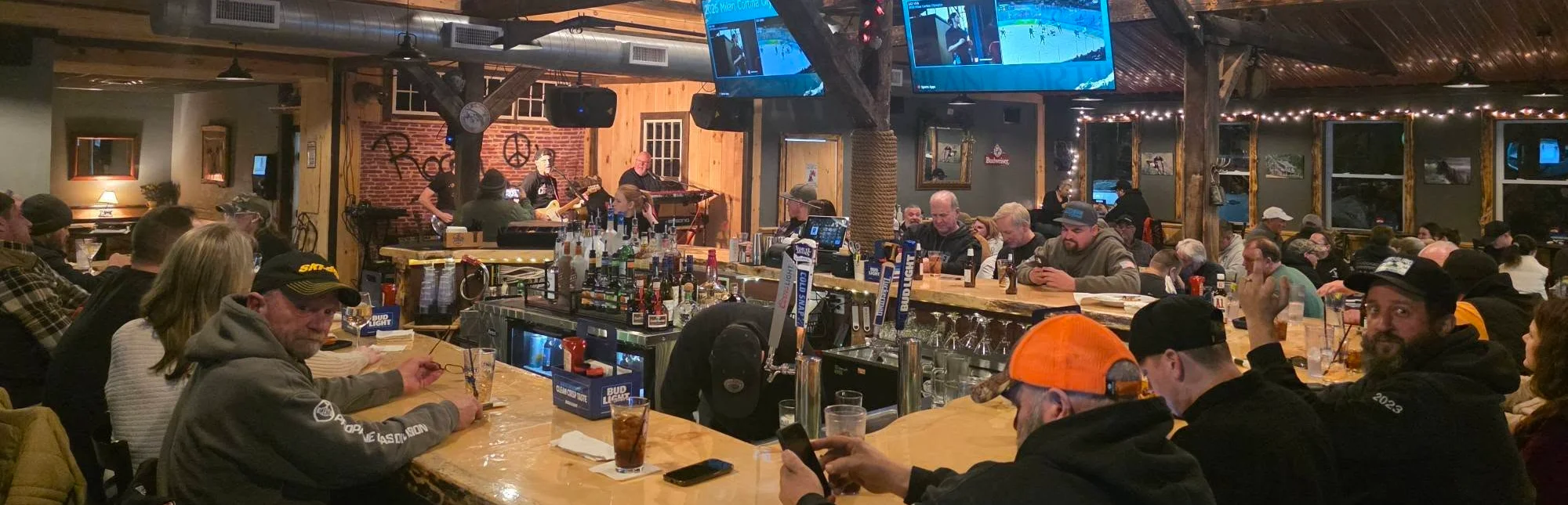 Cozy bar scene with patrons enjoying drinks and sports on TV