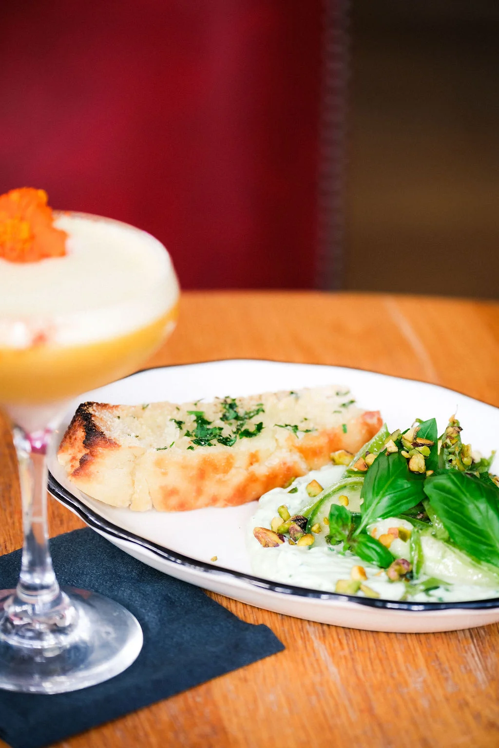 Garlic bread and fresh salad with cocktail in a cozy restaurant setting