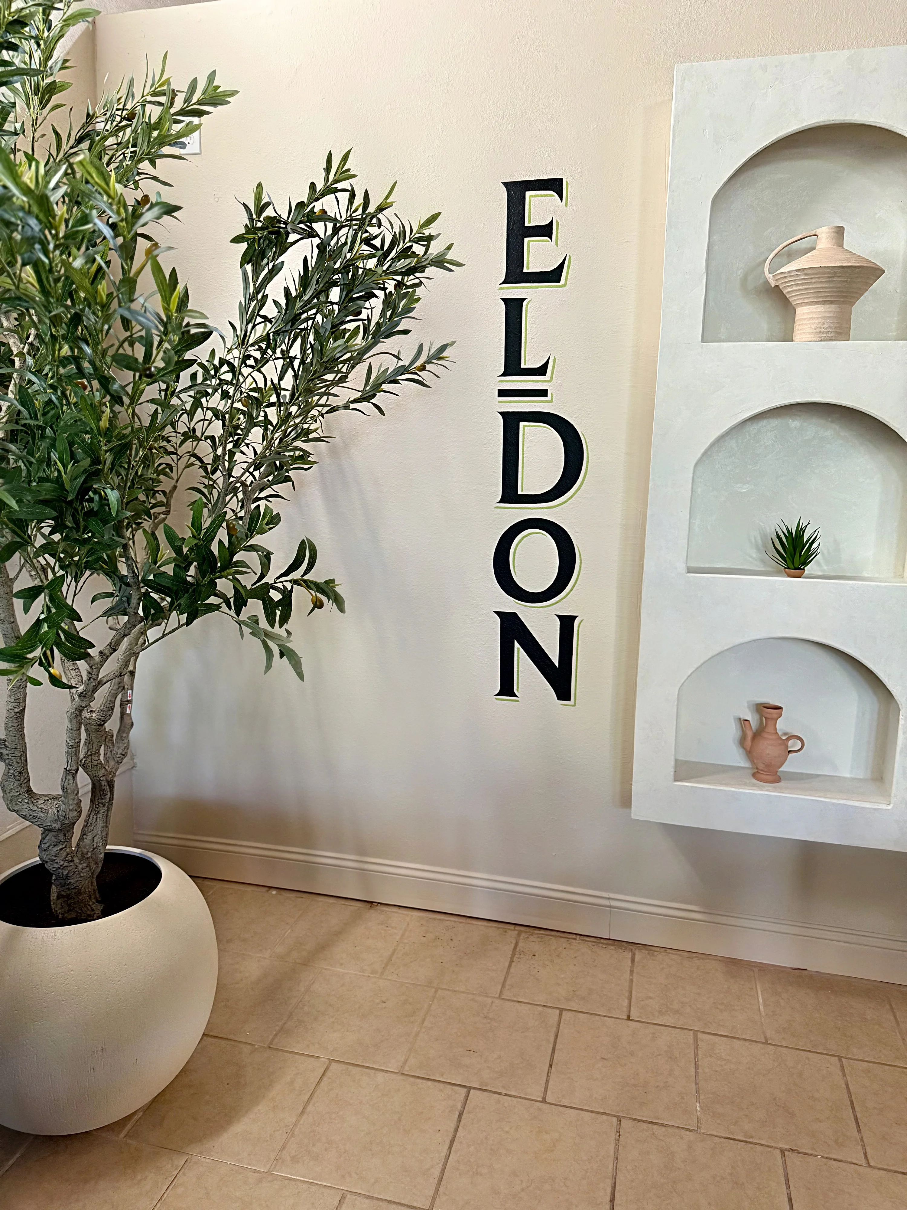 Stylish restaurant interior with olive tree and decorative wall features